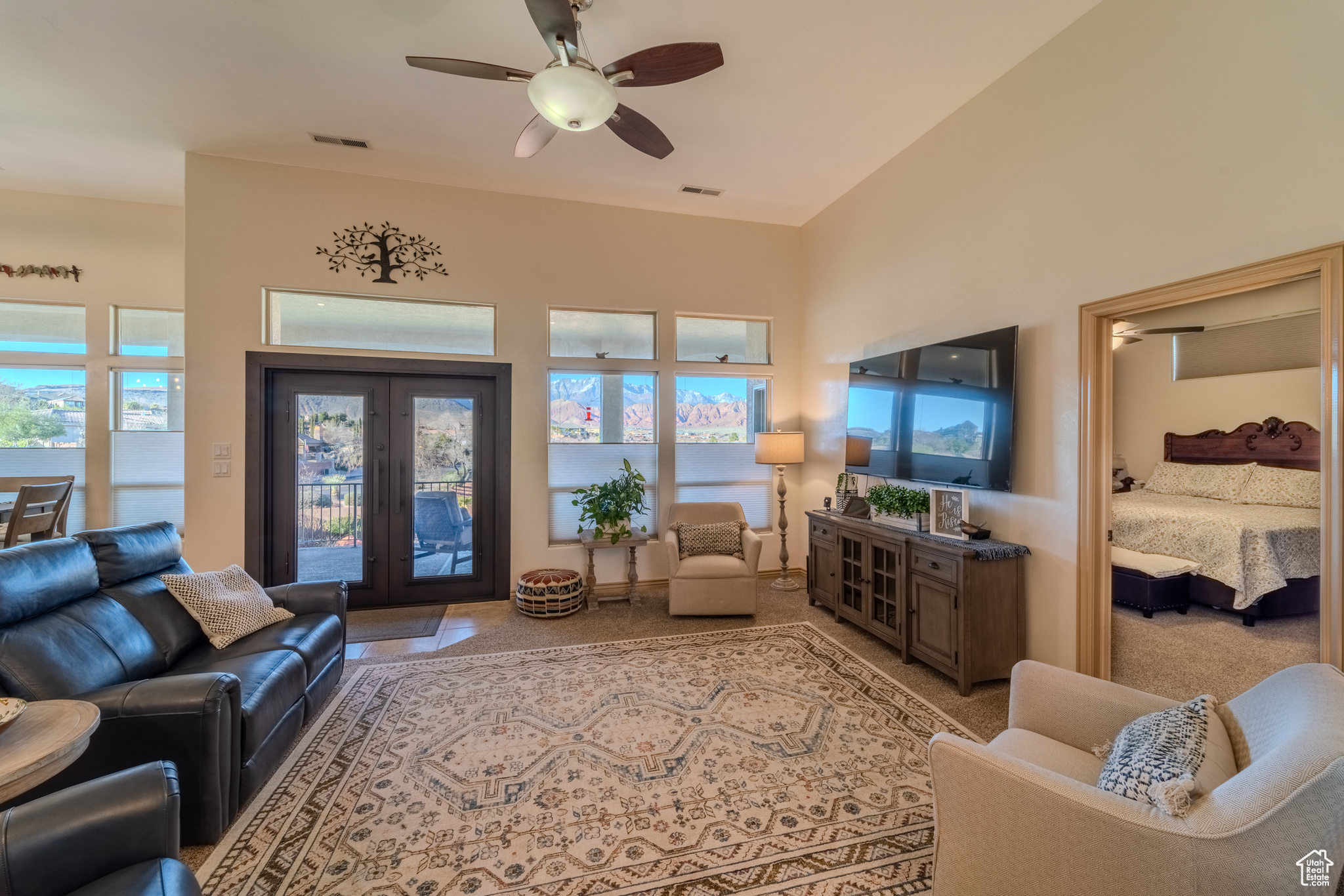 Living room featuring a wealth of natural light, ceiling fan, and french doors