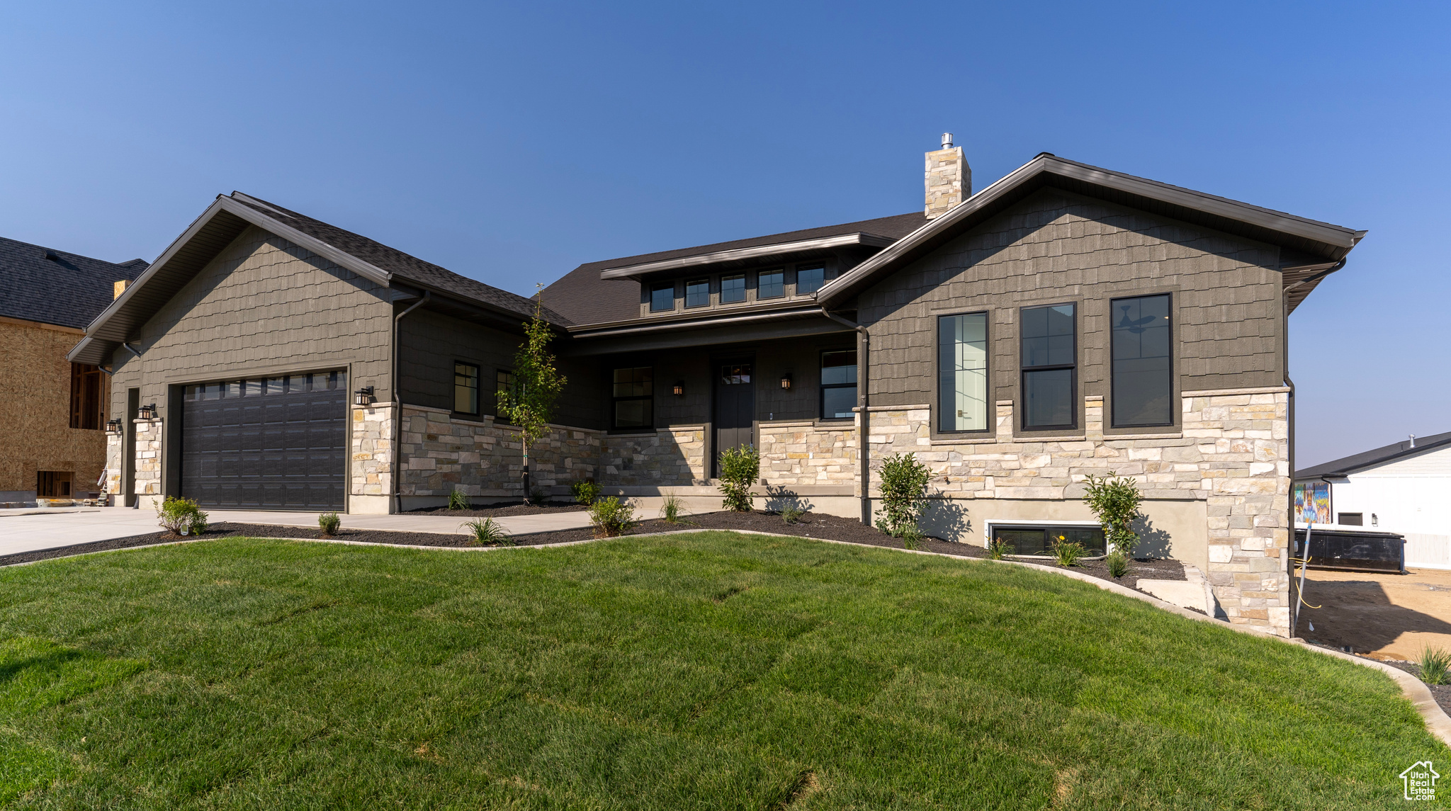 View of front of property featuring a front lawn and a garage