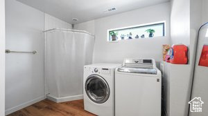 Washroom featuring separate washer and dryer and wood-type flooring