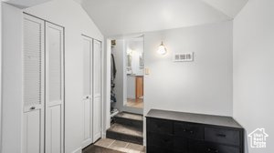 Tiled bedroom featuring vaulted ceiling