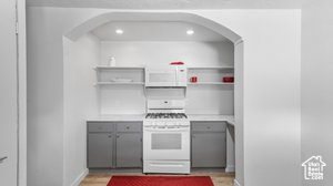 Kitchen featuring gray cabinets and white appliances