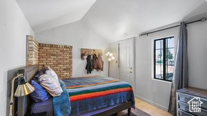 Bedroom featuring lofted ceiling and wood-type flooring