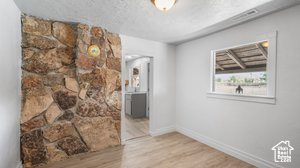 Interior space featuring a textured ceiling and light hardwood / wood-style floors