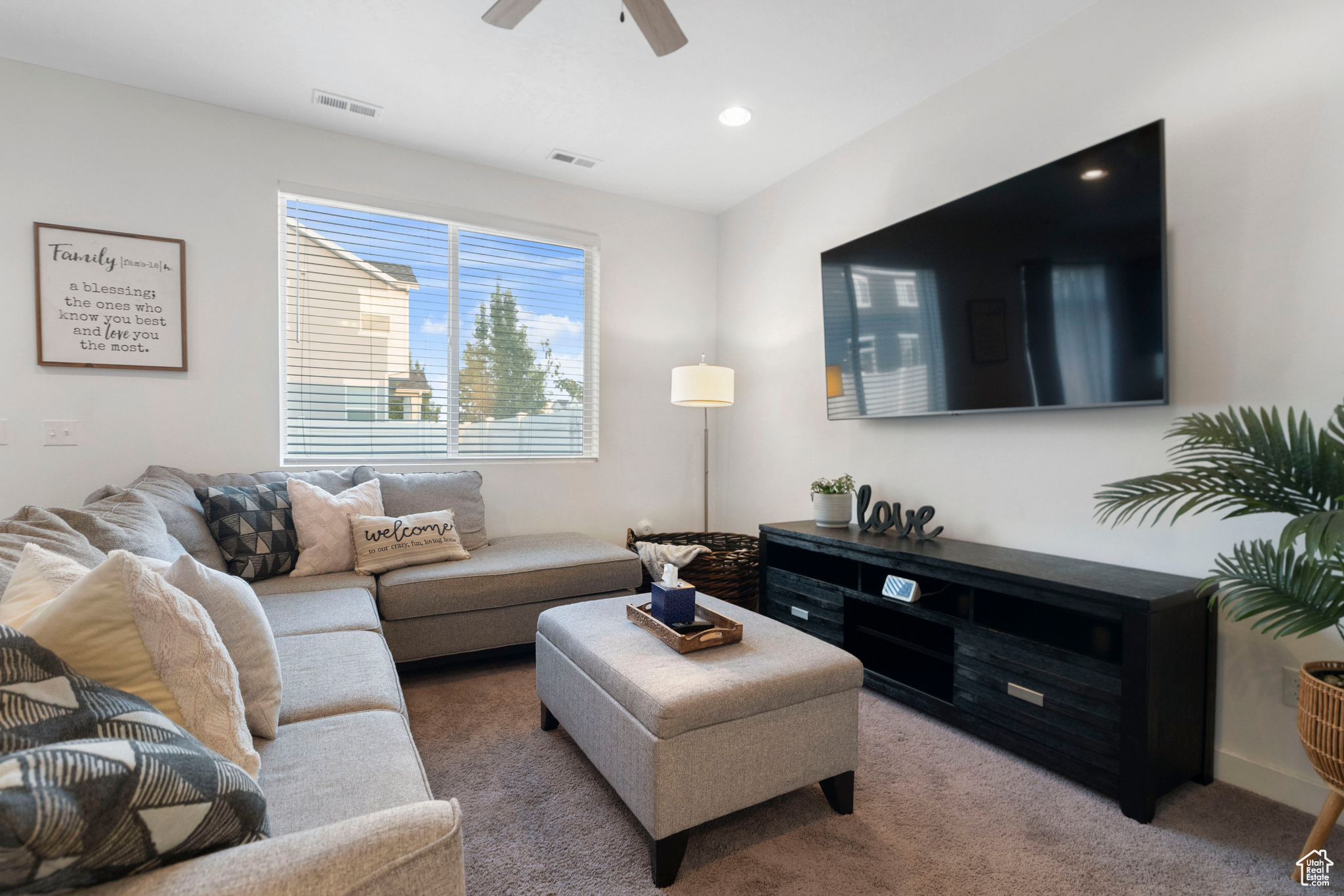 Living room featuring ceiling fan and carpet floors