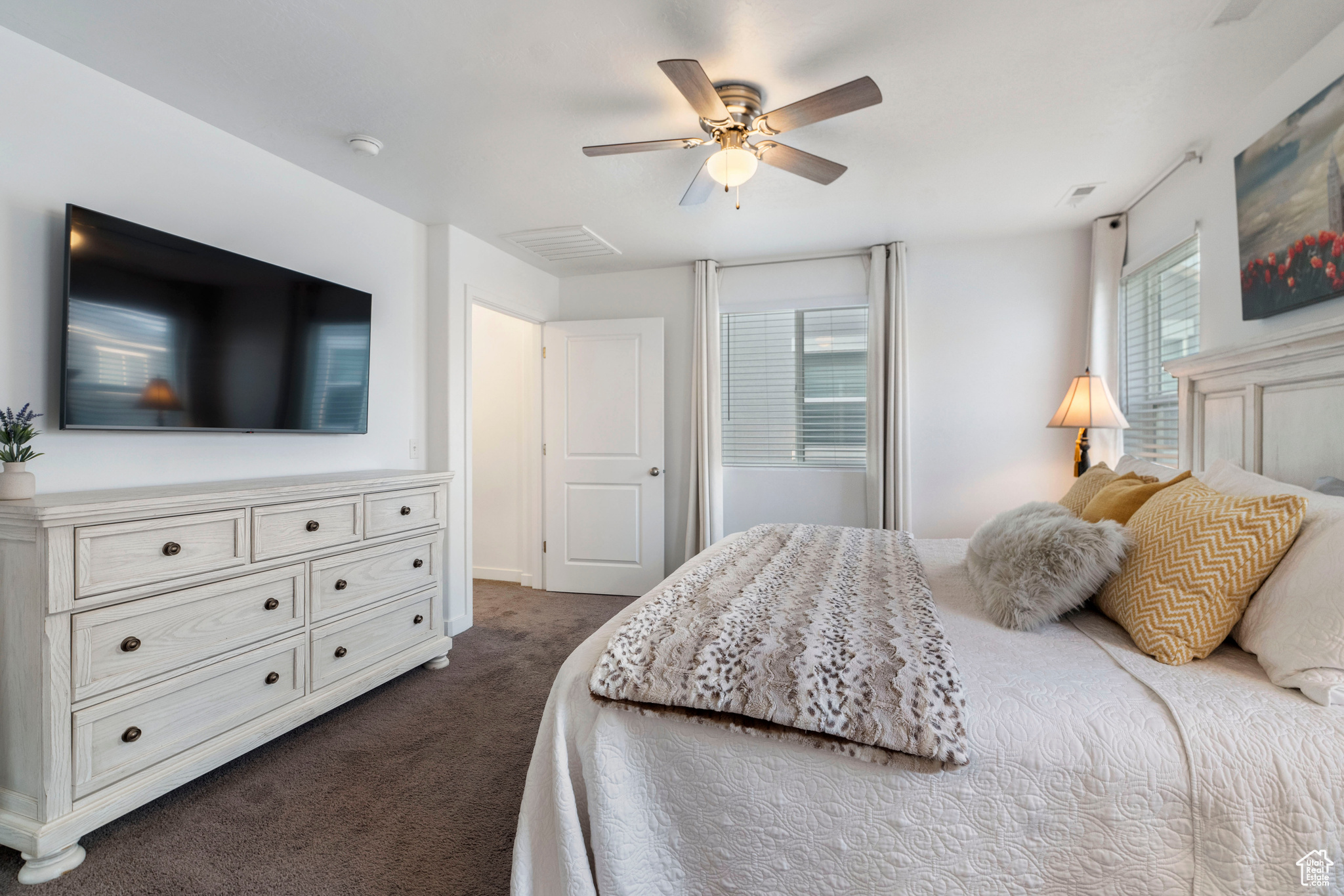 Carpeted bedroom featuring ceiling fan