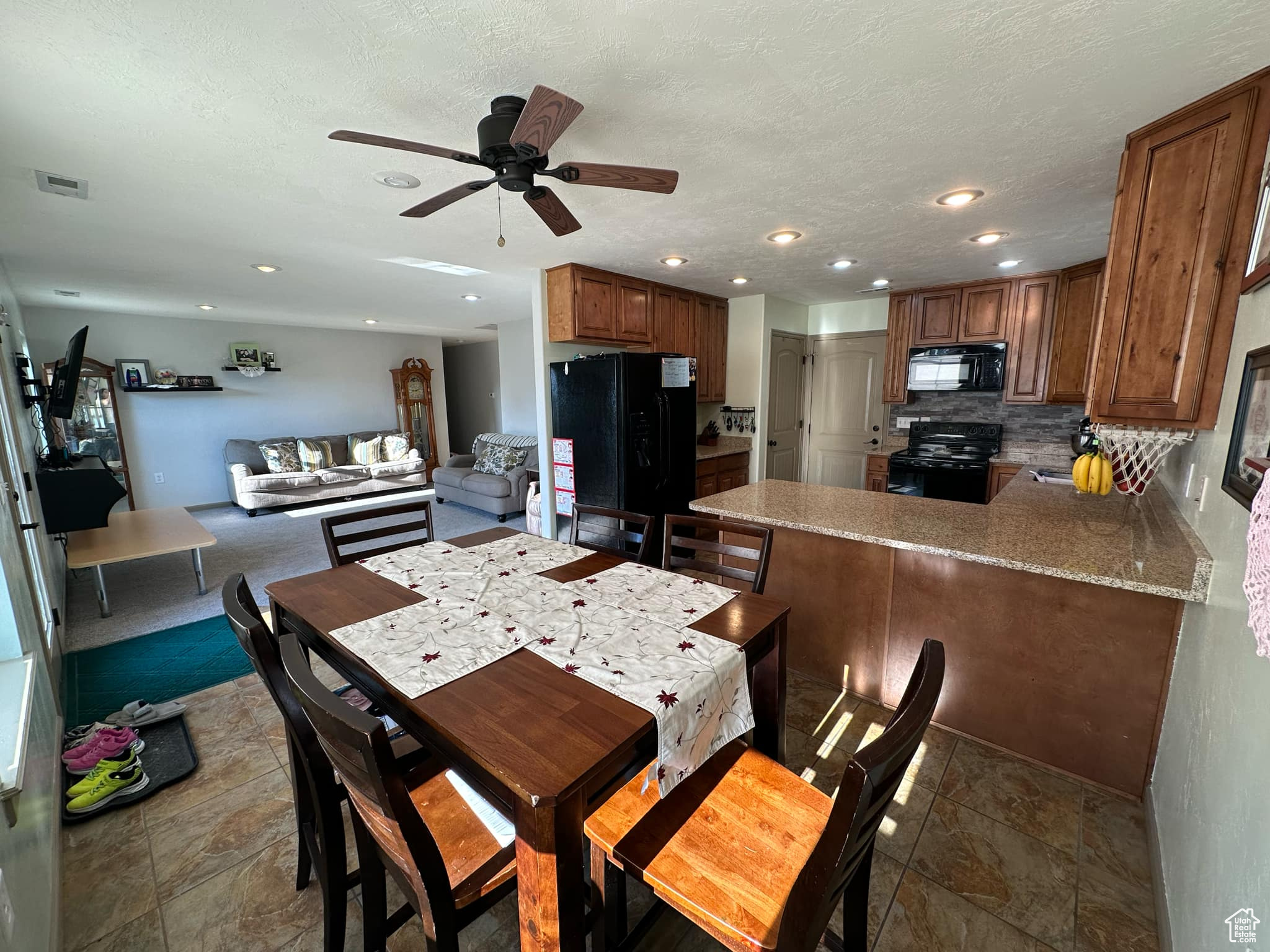 Dining room featuring ceiling fan and a textured ceiling