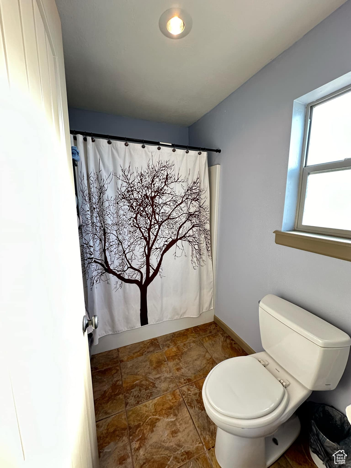 Bathroom with toilet and a shower with curtain