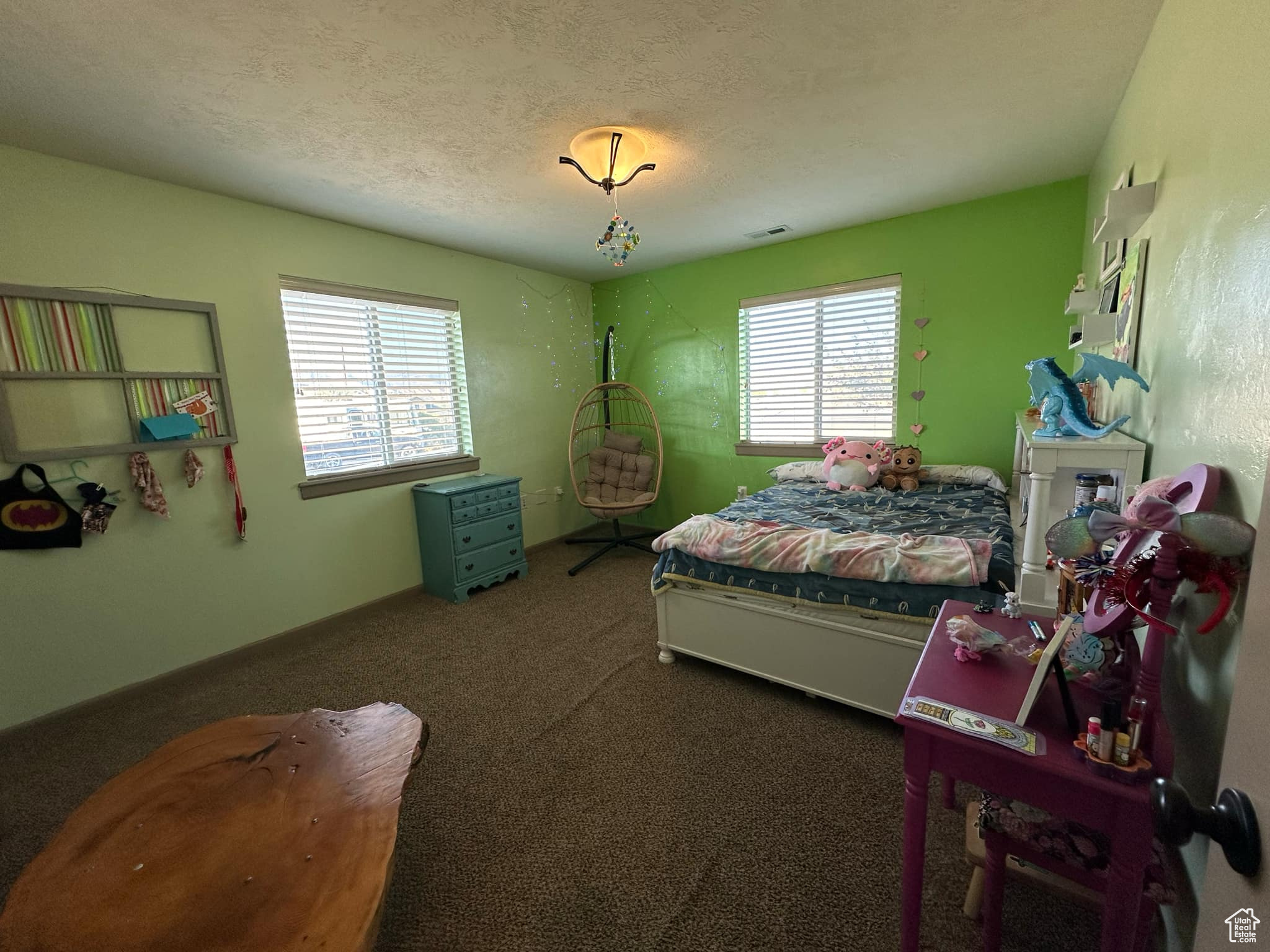 Bedroom with multiple windows, a textured ceiling, and carpet floors