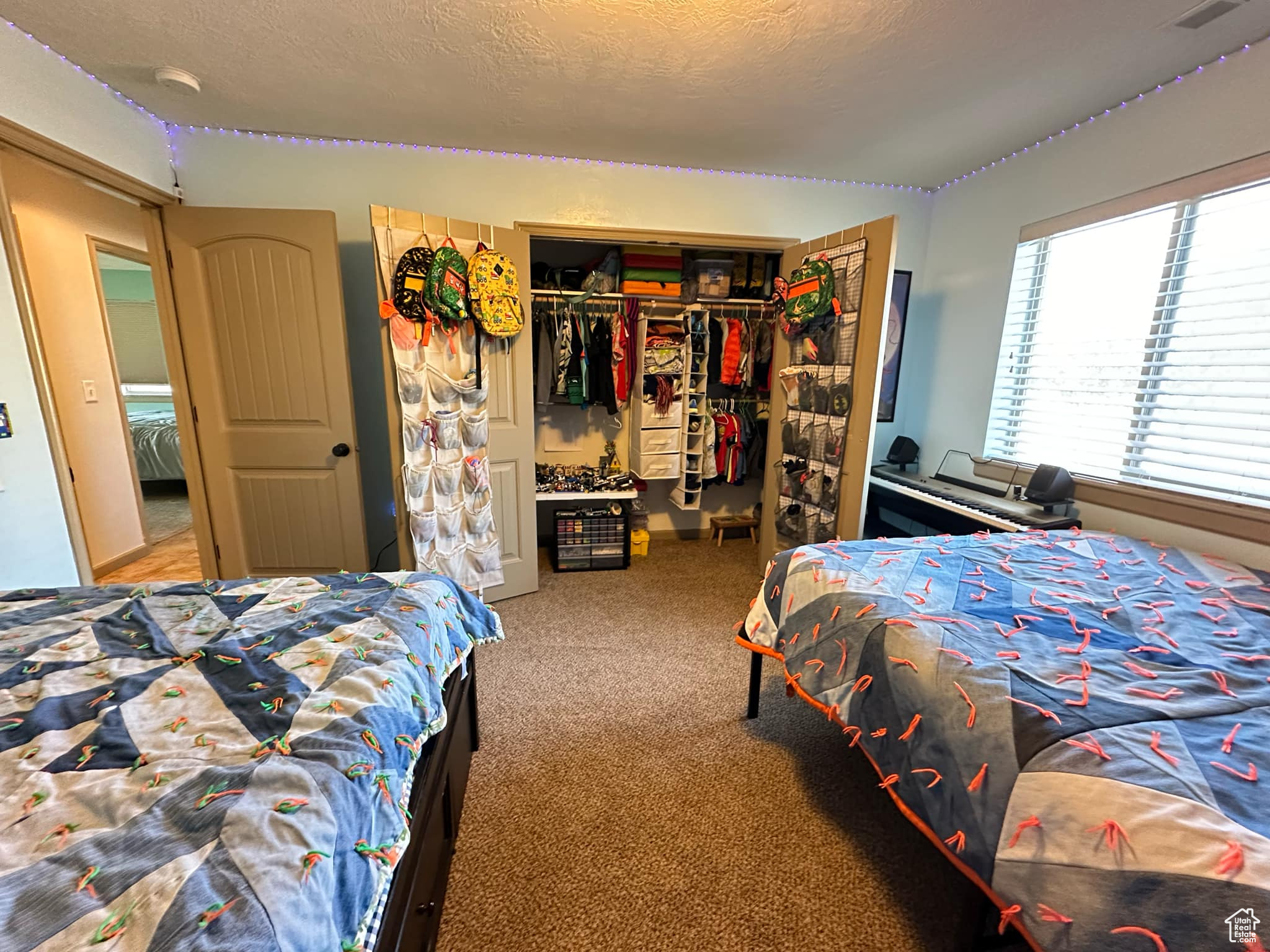 Bedroom featuring a closet, carpet flooring, and a textured ceiling