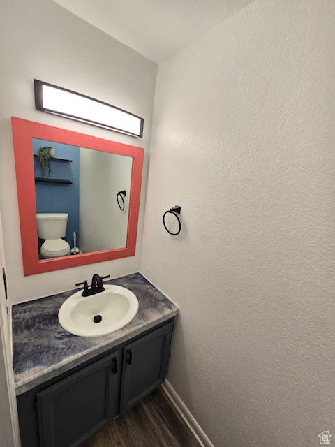 Bathroom with vanity, wood-type flooring, and toilet