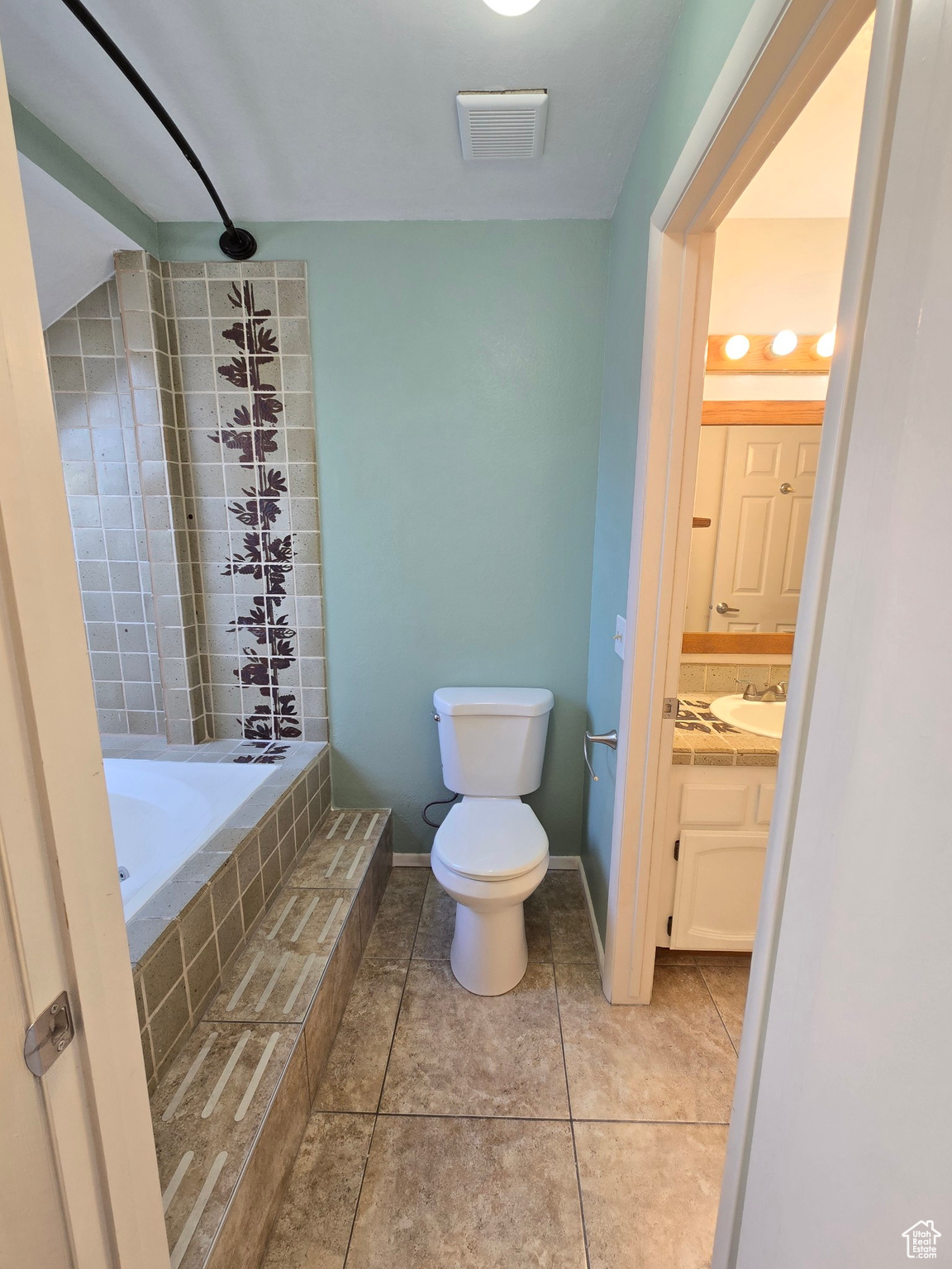 Bathroom featuring tile patterned floors, vanity, and toilet