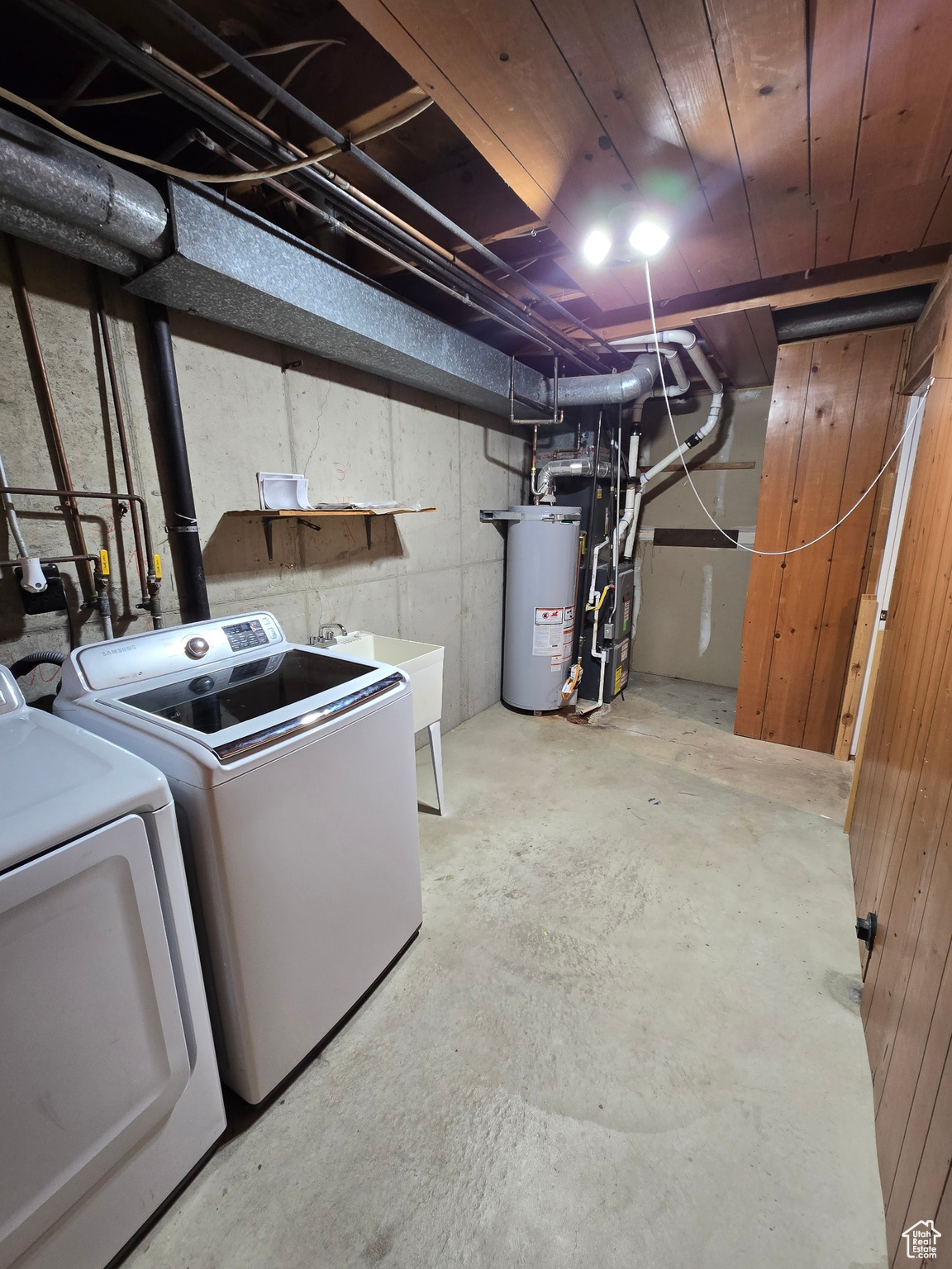 Basement with independent washer and dryer, gas water heater, heating unit, and sink