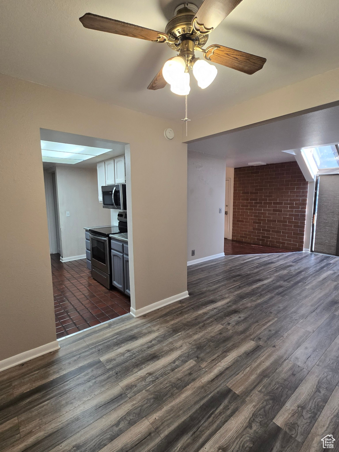 Interior space with ceiling fan and dark hardwood / wood-style floors