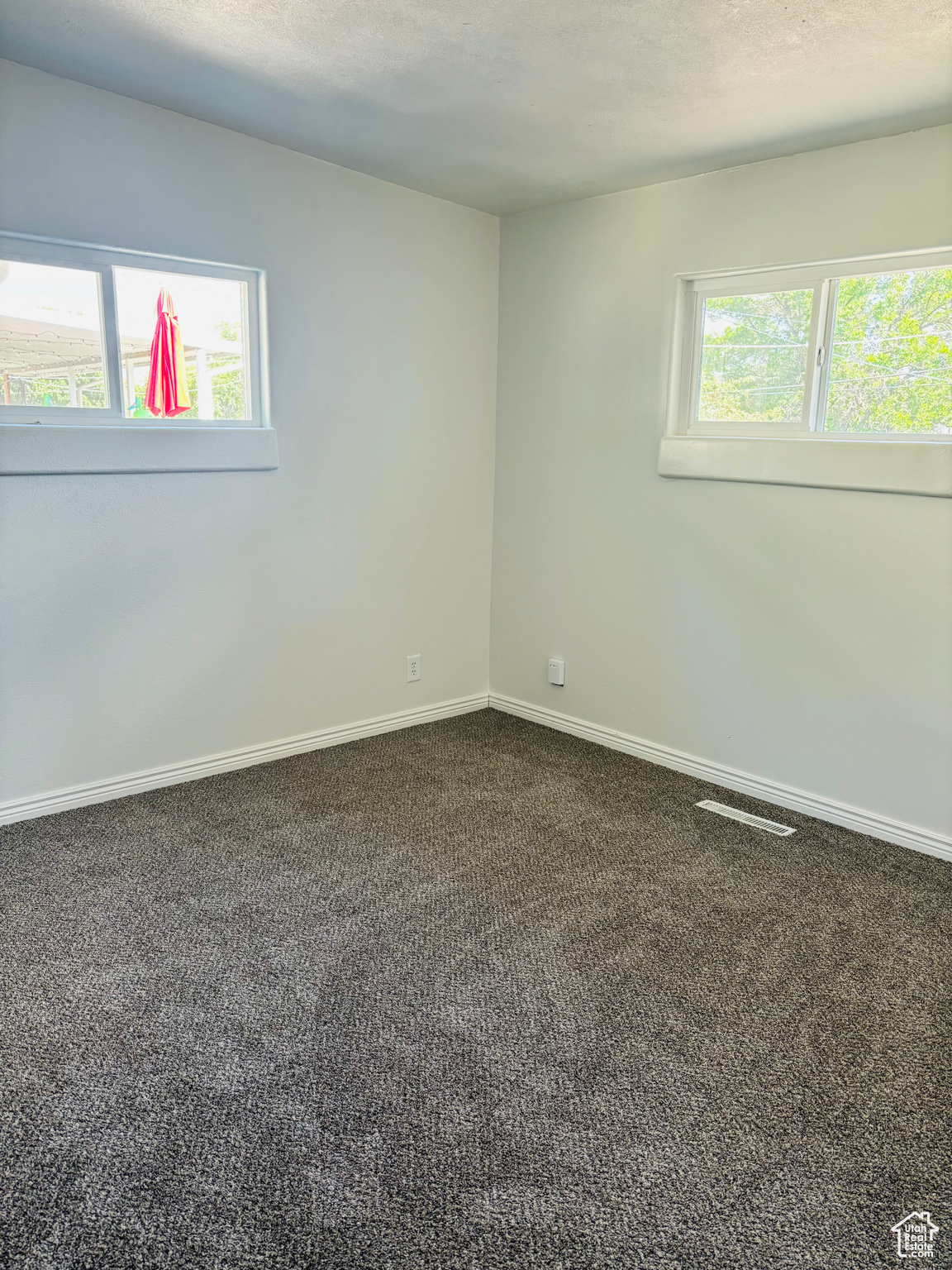 Carpeted empty room featuring a wealth of natural light