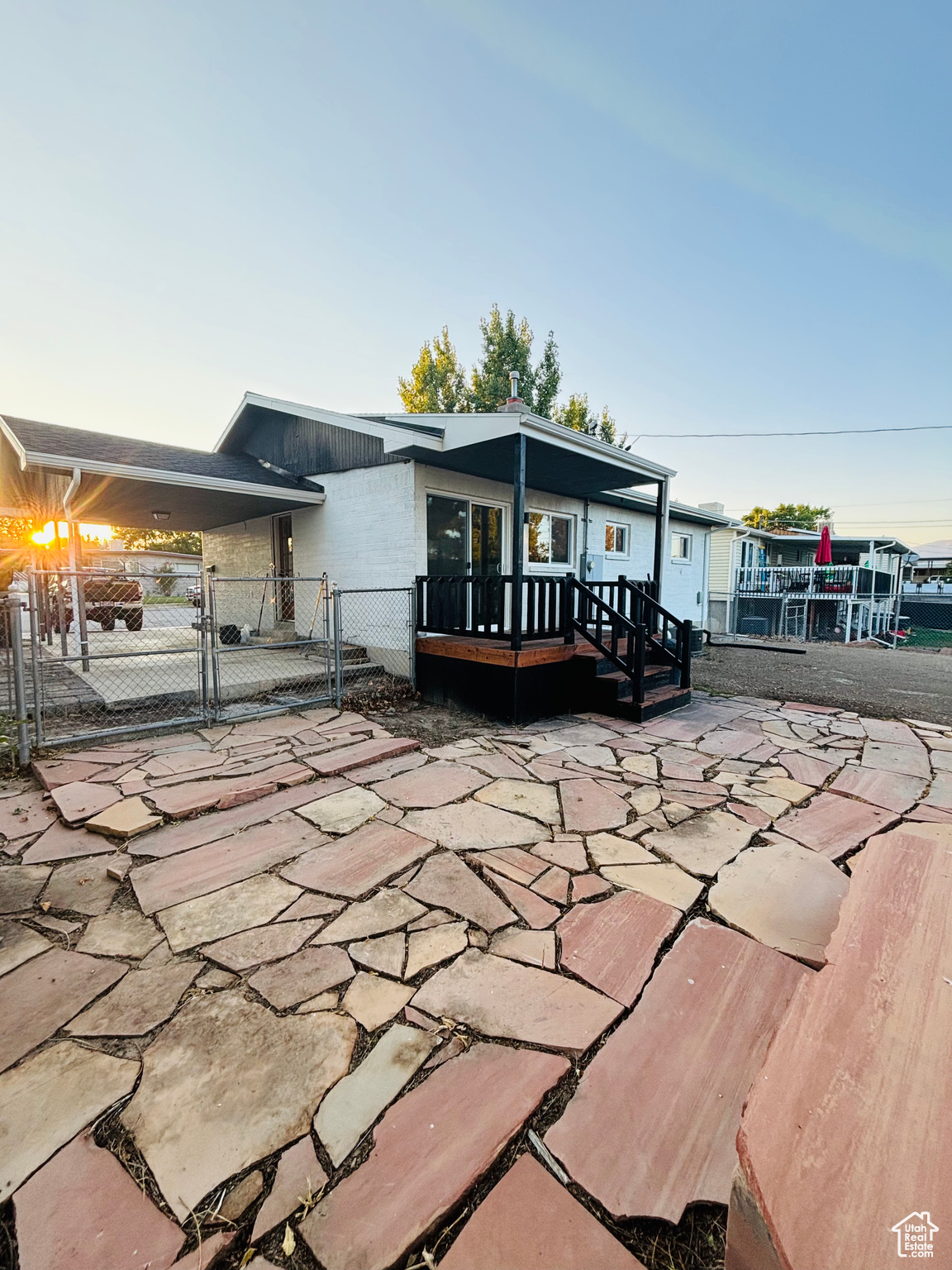 Exterior space with a wooden deck and a patio