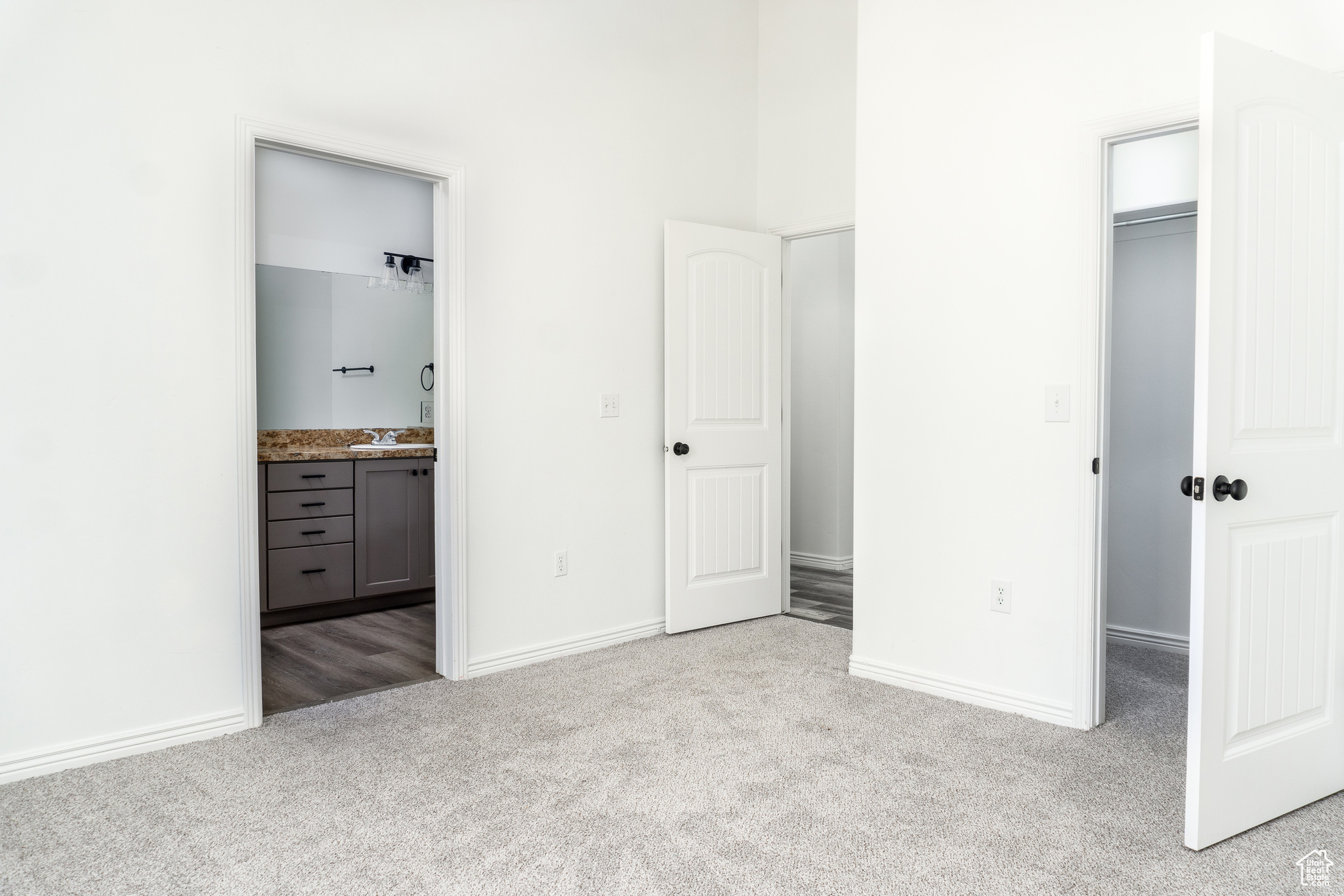 Master Bedroom-Unfurnished bedroom with sink, ensuite bathroom, light colored carpet, and a closet