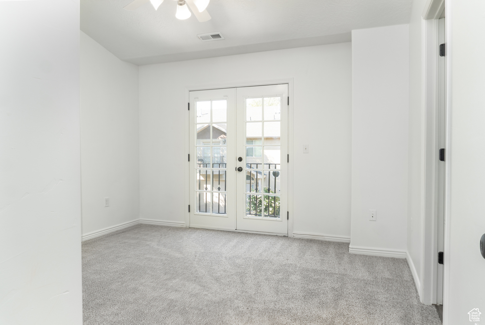 Master bedroom-Unfurnished room featuring light colored carpet, ceiling fan, and french doors