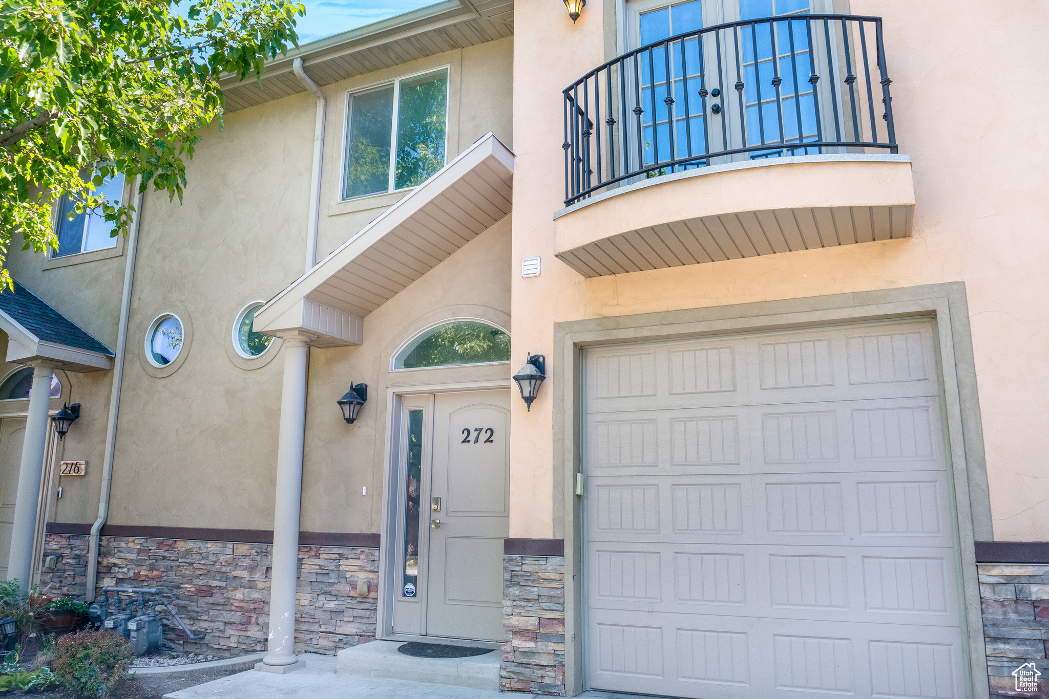 View of front of property featuring a balcony and a garage