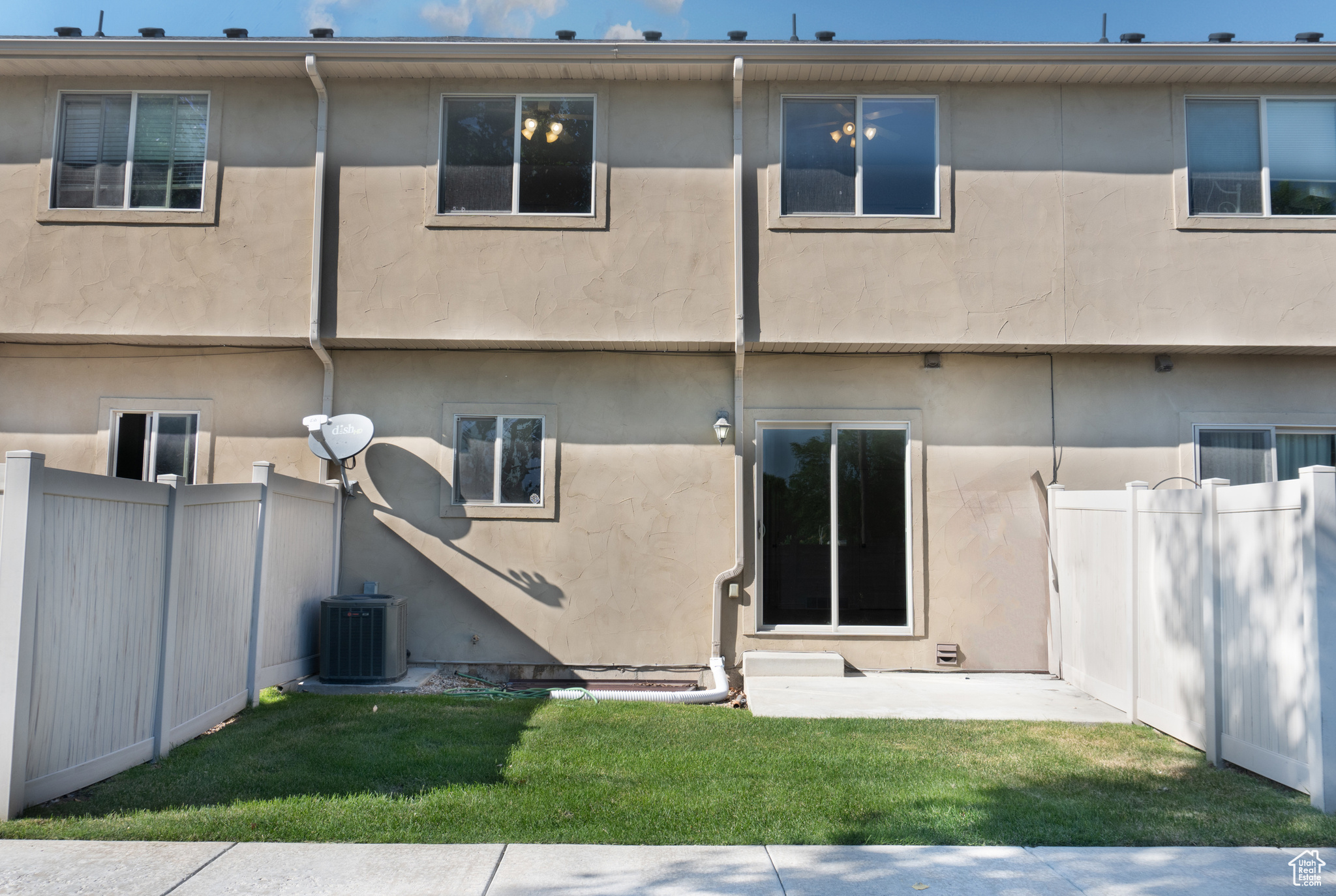 Back of property featuring a lawn and central air condition unit