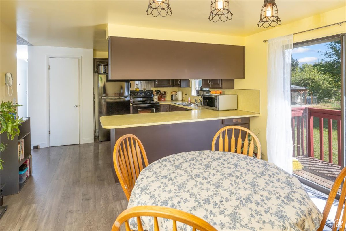 Kitchen with dark wood-type flooring,  appliances, sink, and kitchen peninsula