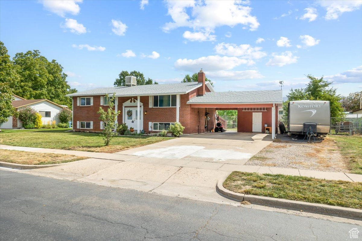 View of front facade featuring a carport and a front lawn