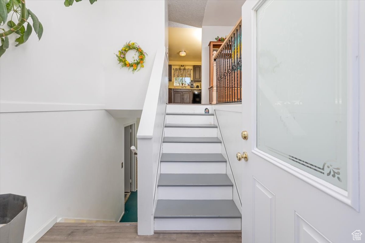 Stairs featuring hardwood / wood-style flooring