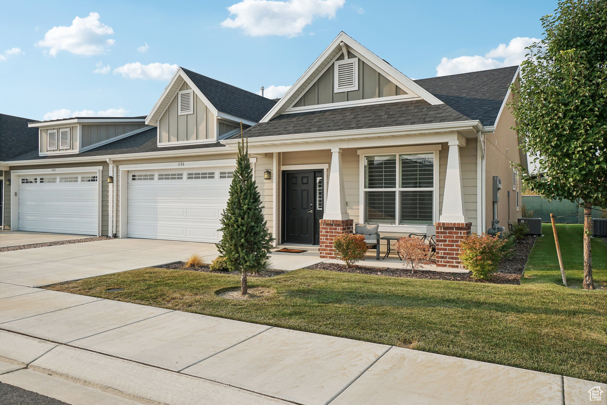 Craftsman-style house with a front yard and central AC unit