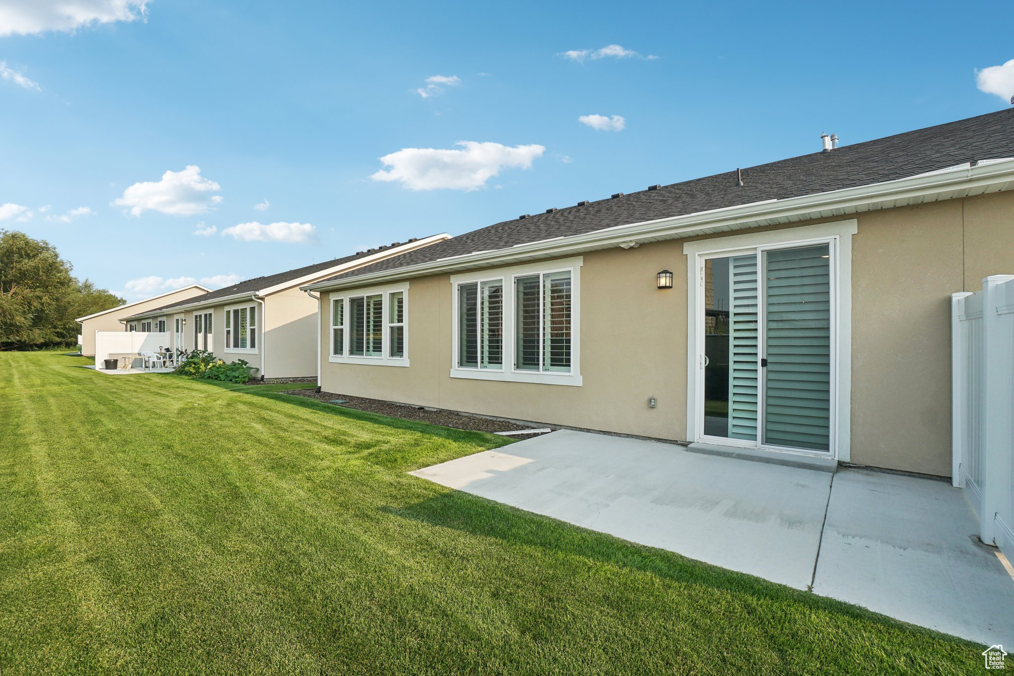 Rear view of house featuring a lawn and a patio