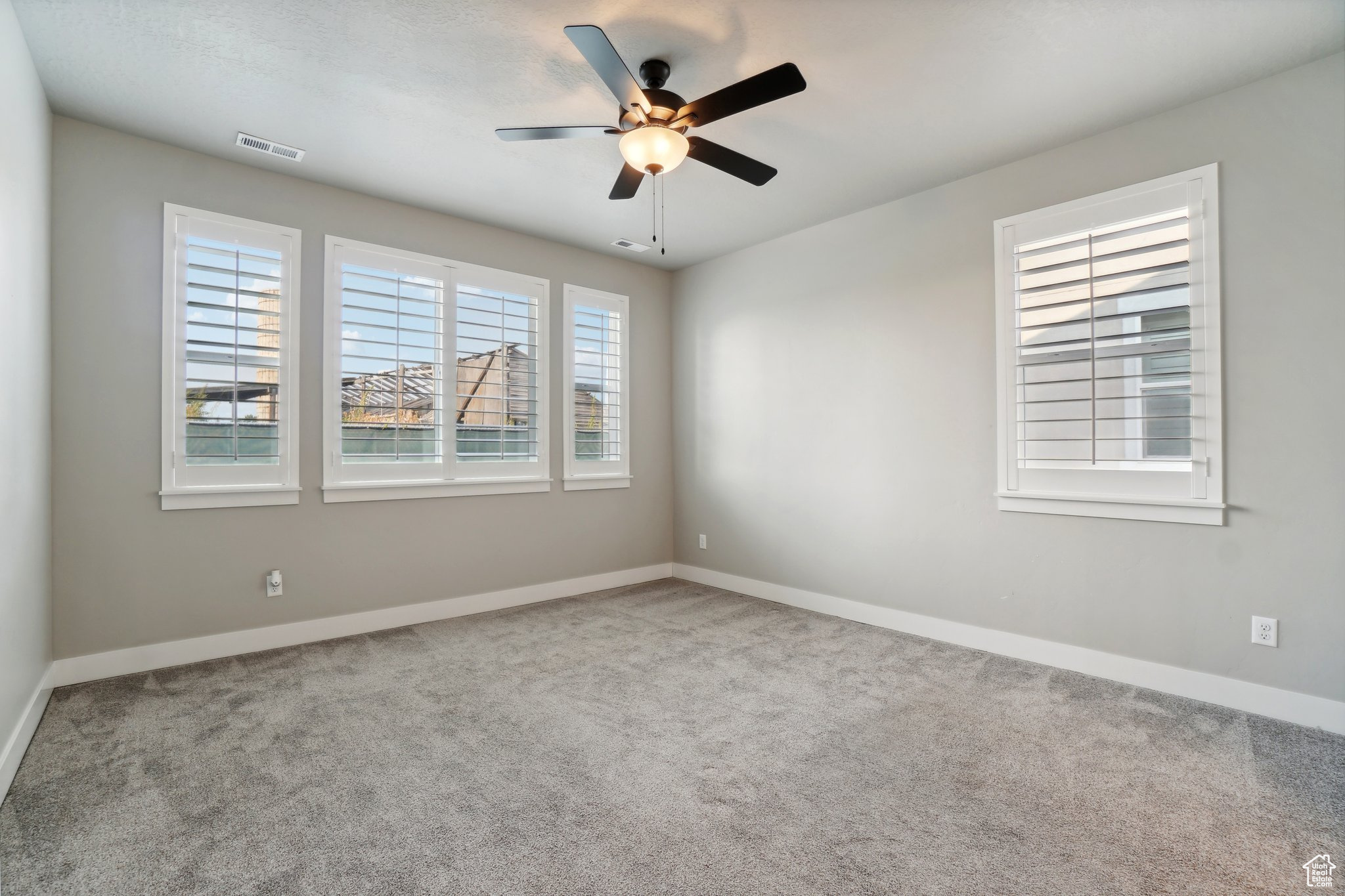 Carpeted empty room with ceiling fan