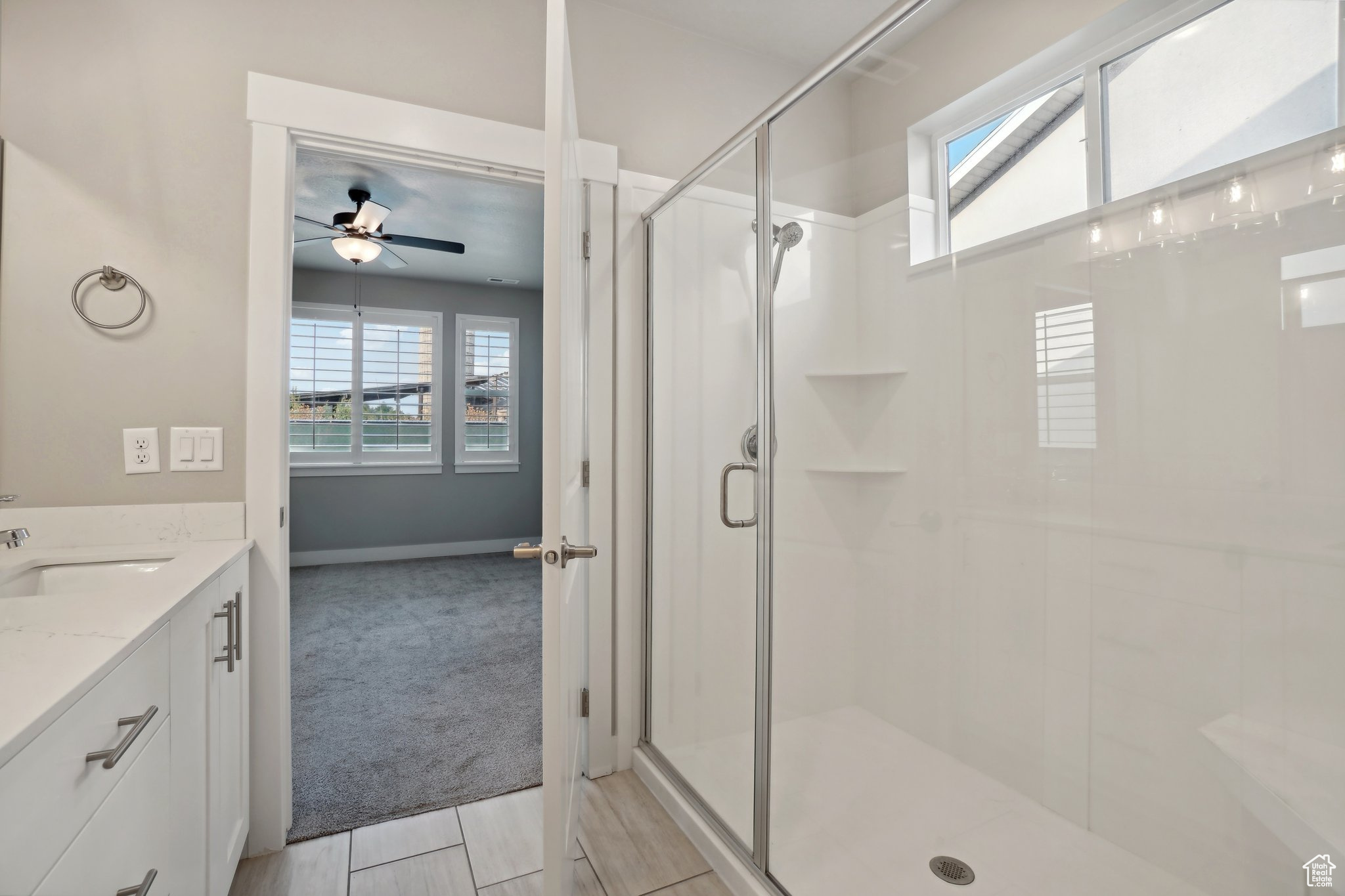 Bathroom with a shower with door, vanity, and ceiling fan