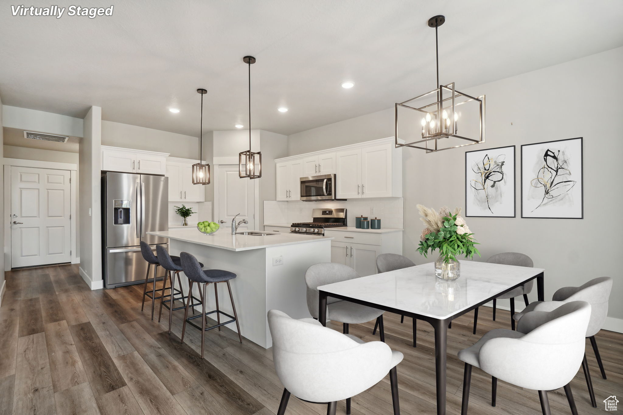 Kitchen featuring appliances with stainless steel finishes, sink, pendant lighting, and dark hardwood / wood-style floors