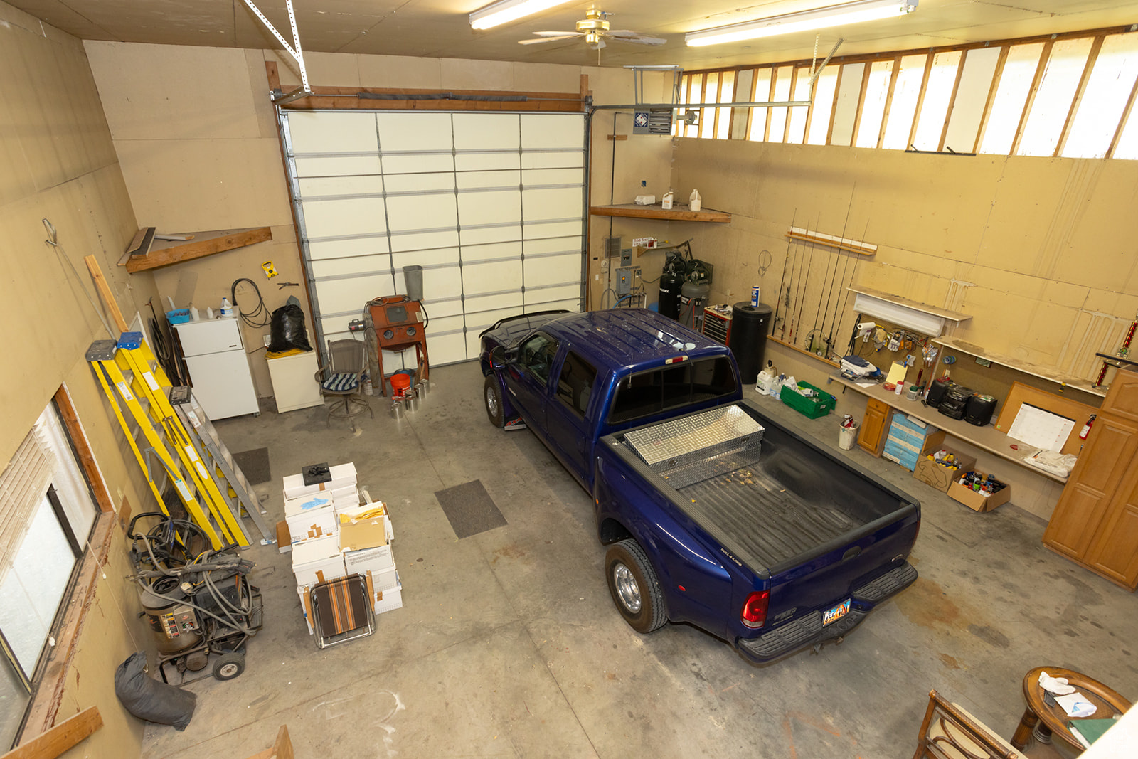 Garage with ceiling fan and white fridge