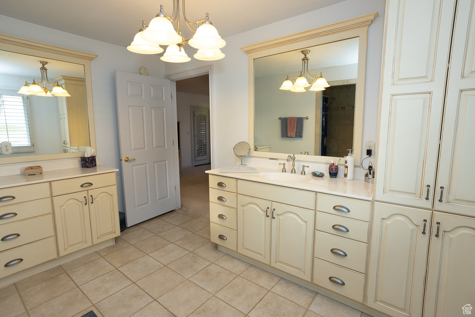 Bathroom featuring tile patterned flooring, vanity, and a notable chandelier