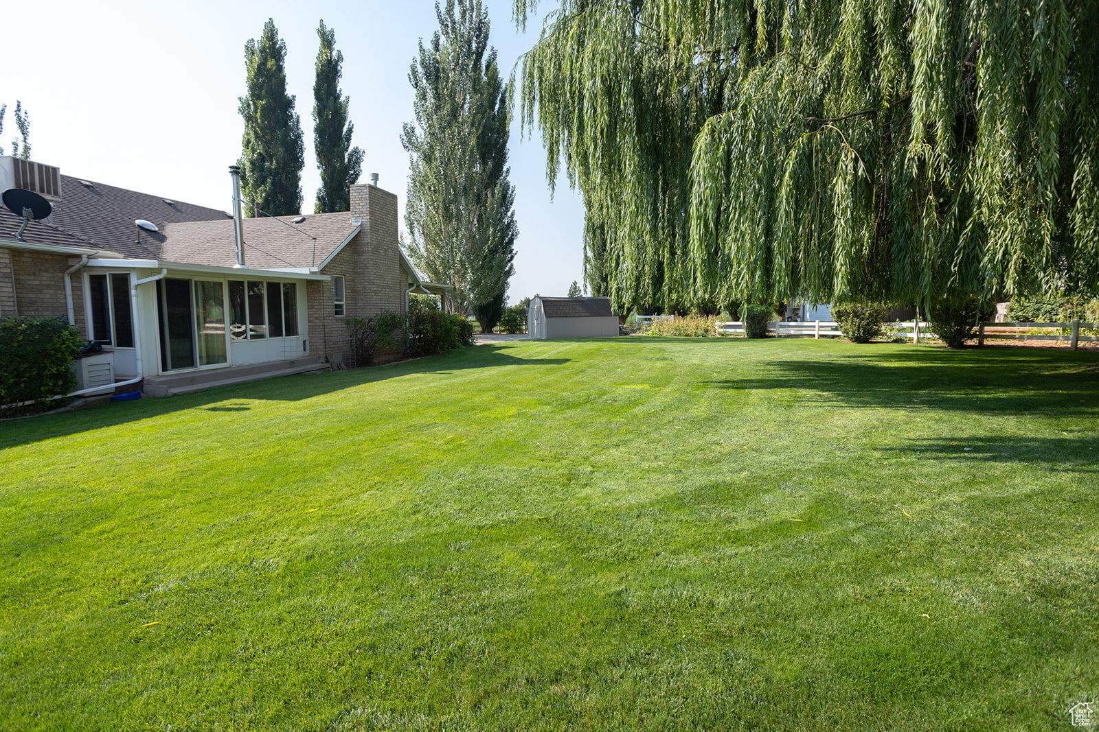 View of yard with a storage shed and a sunroom