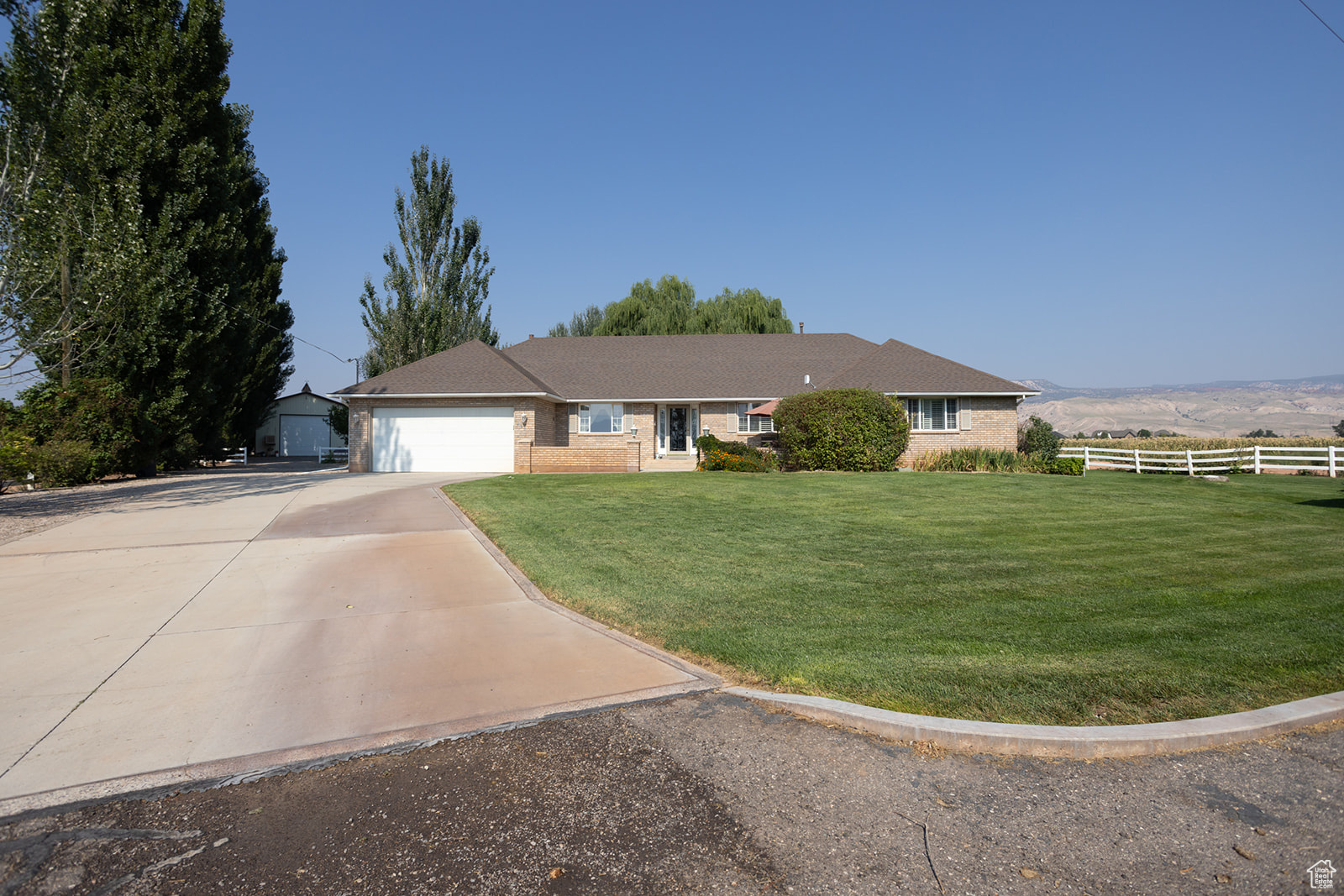 Single story home featuring a front lawn, a garage, and a mountain view