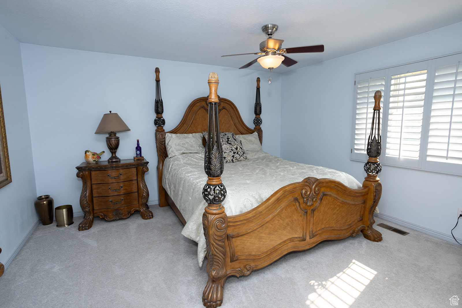 Carpeted bedroom featuring ceiling fan