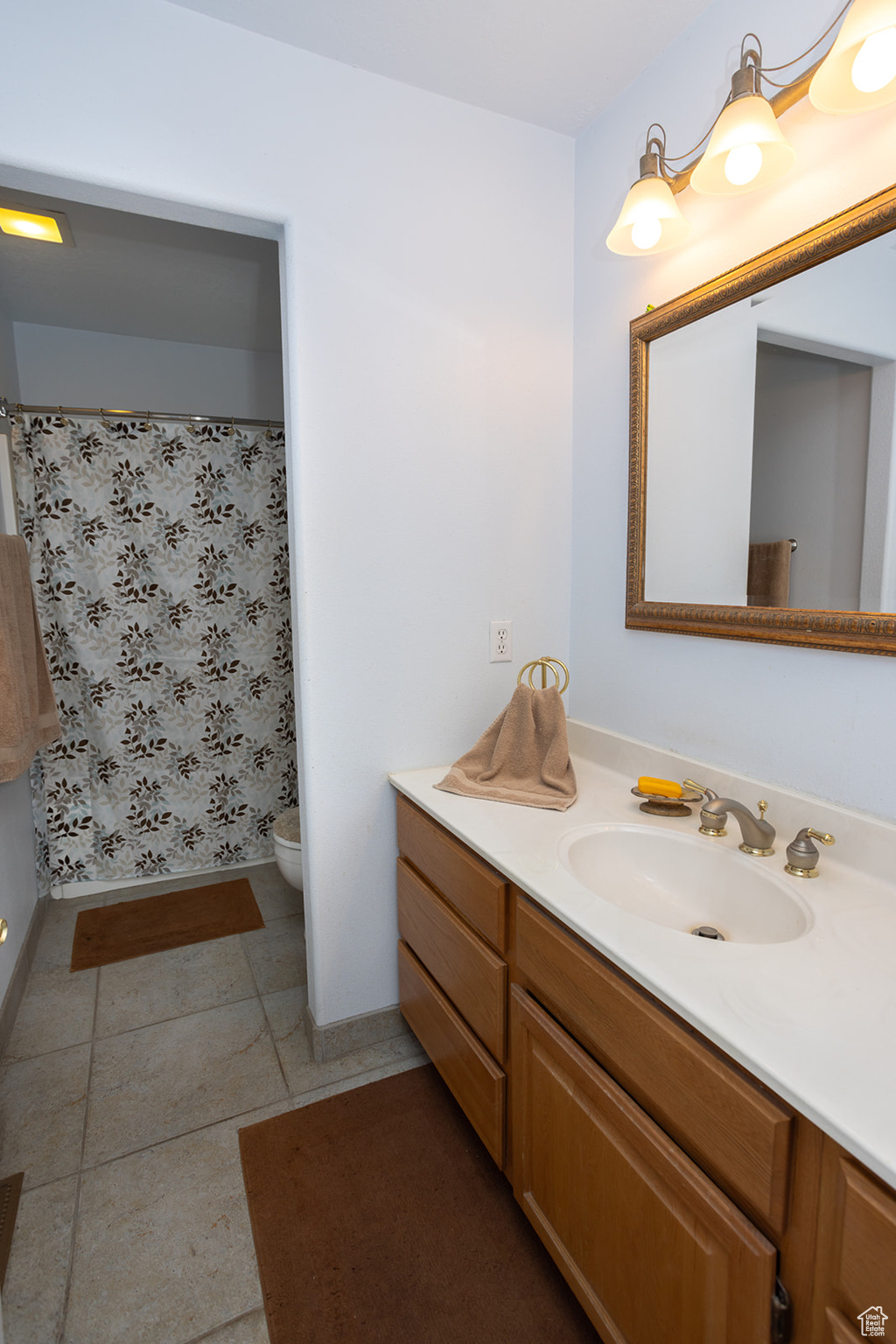 Bathroom with vanity, toilet, and tile patterned floors