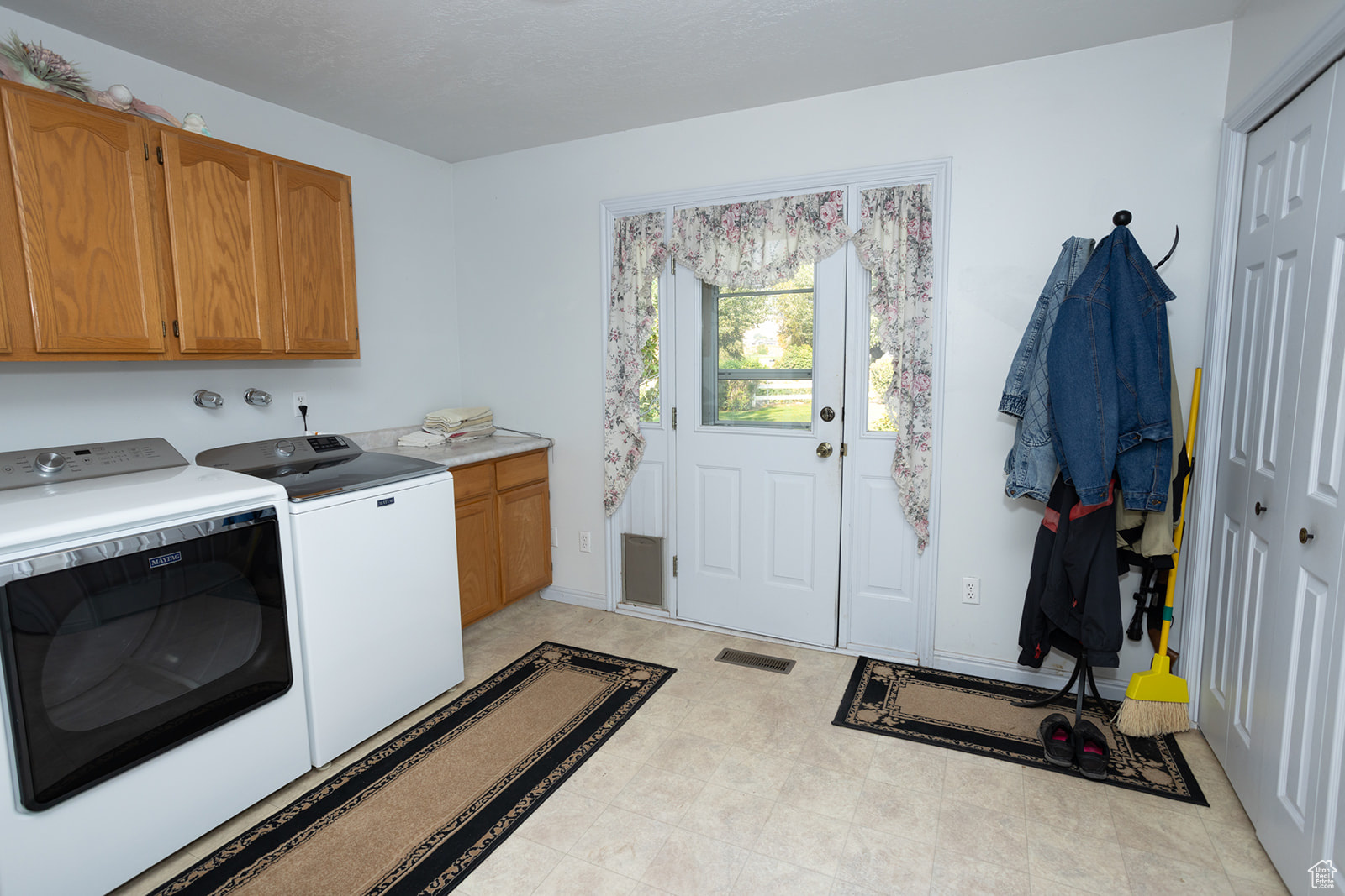 Laundry room with cabinets and washer and clothes dryer