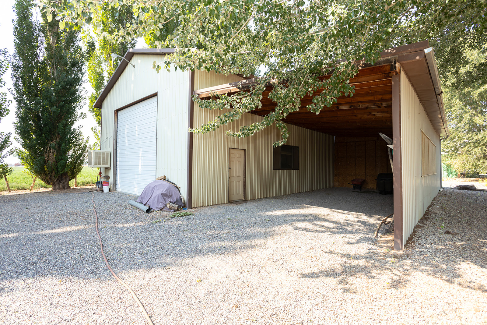 Garage with wood walls and a carport