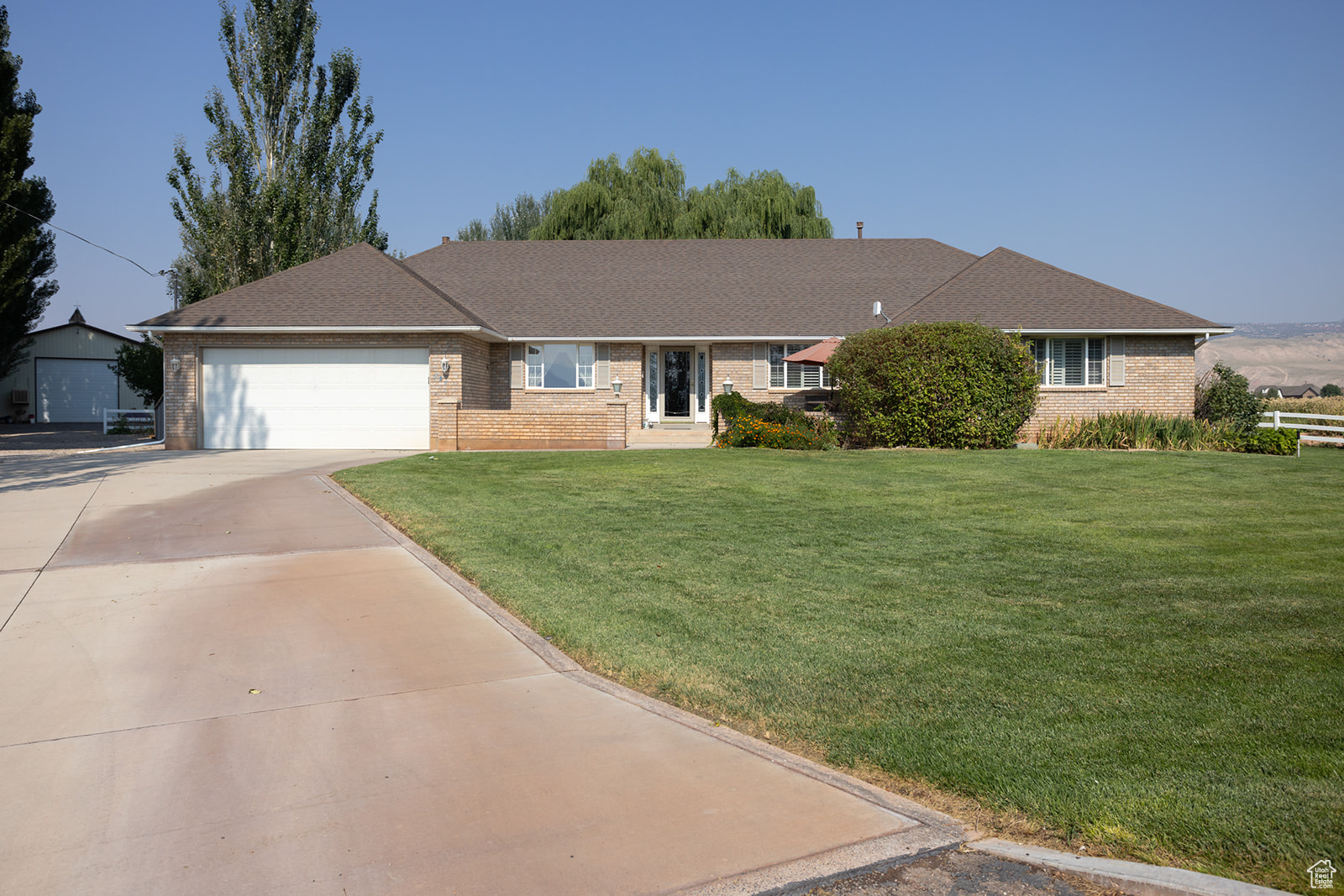 Single story home with a garage and a front lawn