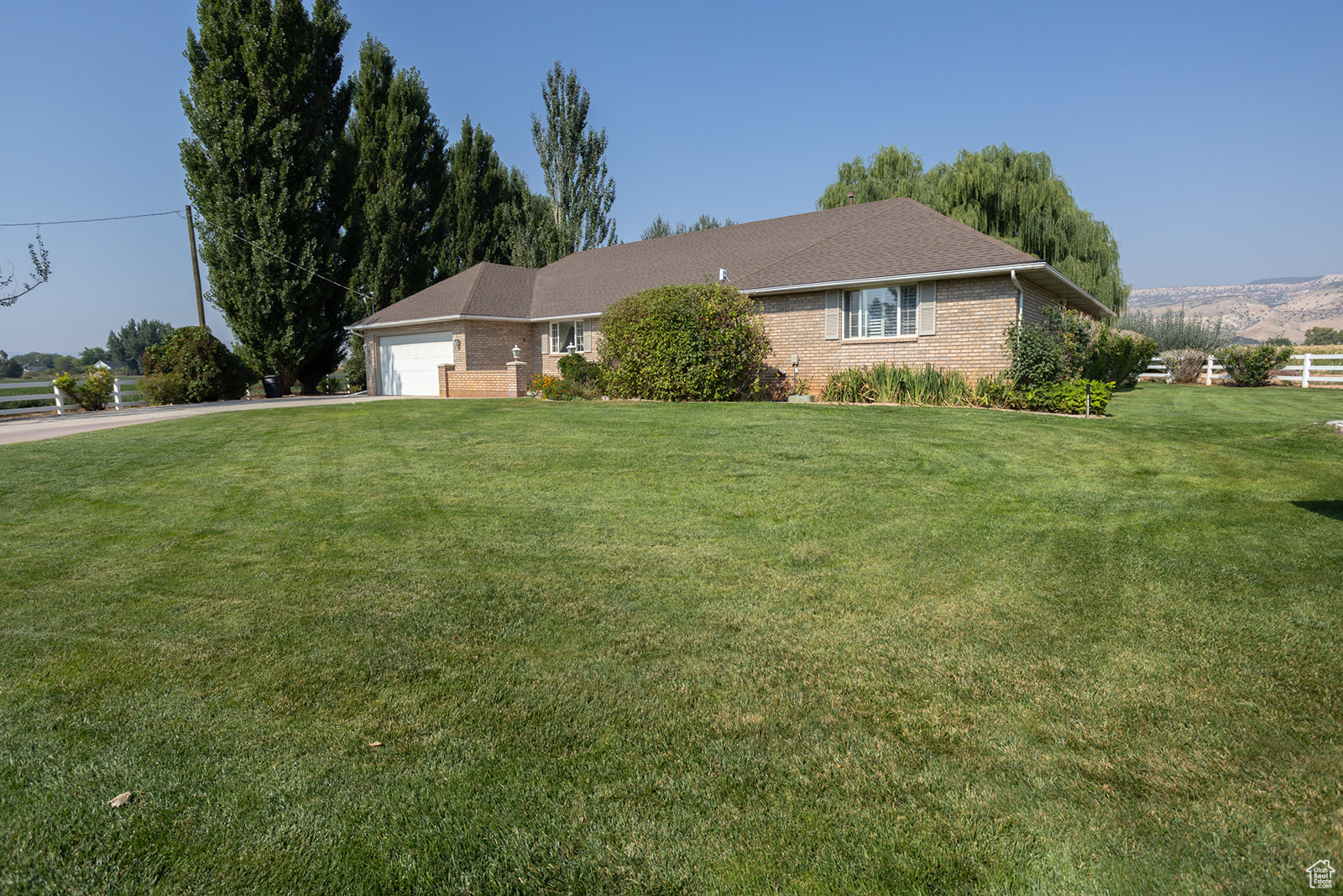 Single story home with a garage and a front yard