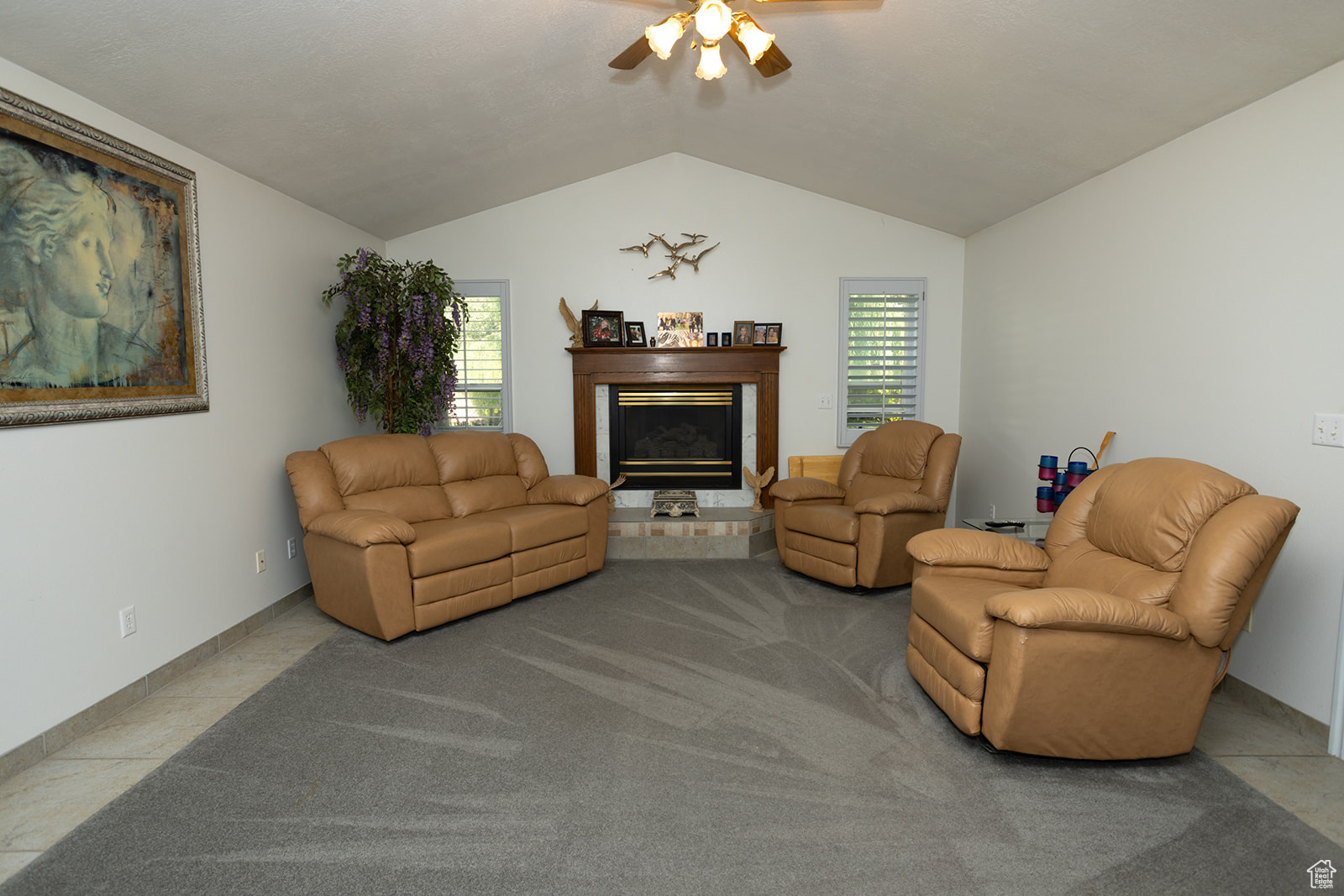 Living room featuring tile patterned flooring, ceiling fan, and vaulted ceiling