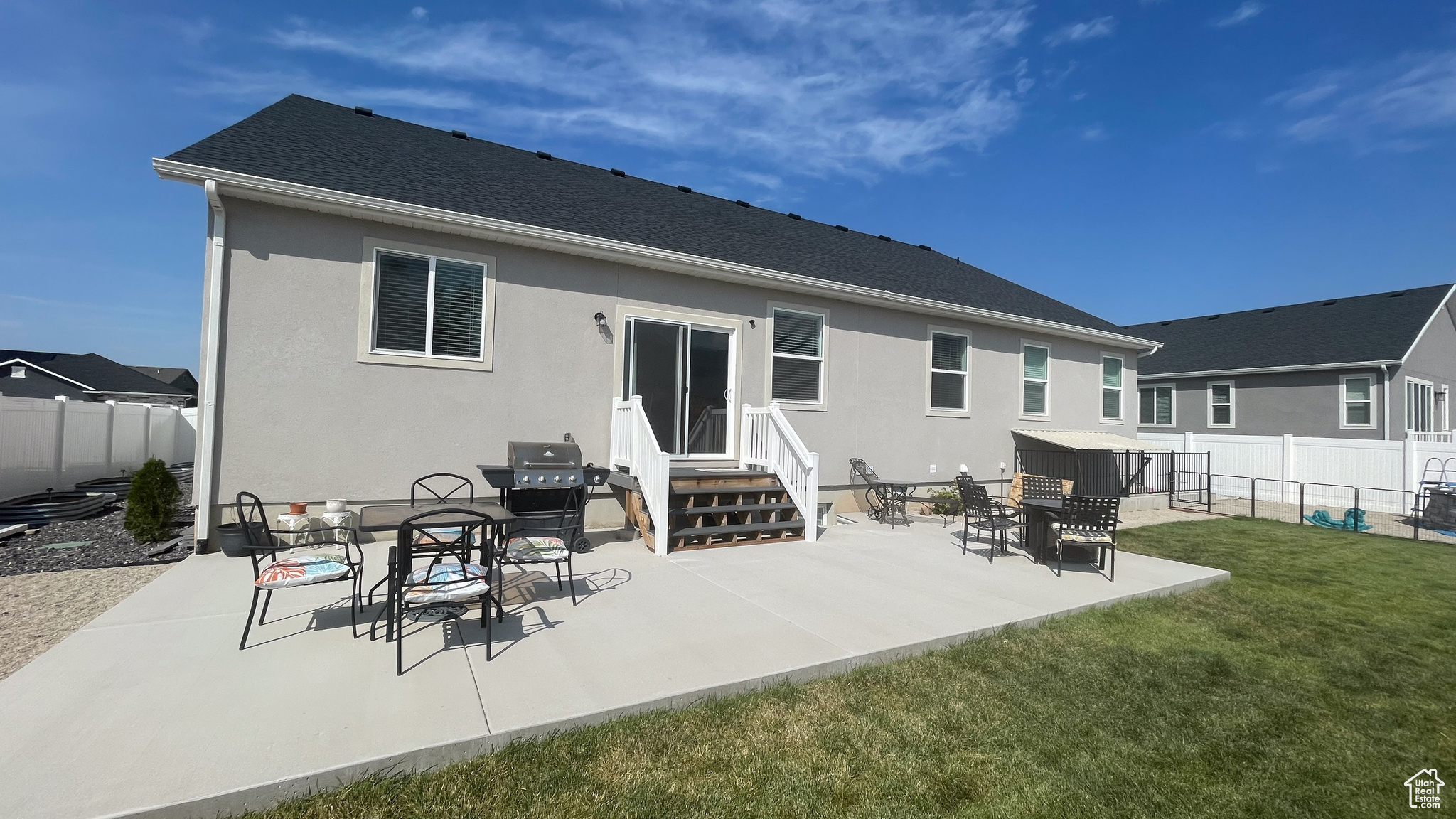 Rear view of house featuring a yard and a large patio area. On the right is the covered outside entrance to the ADU