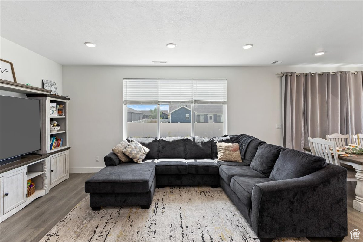 Living room with a textured ceiling and hardwood / wood-style flooring