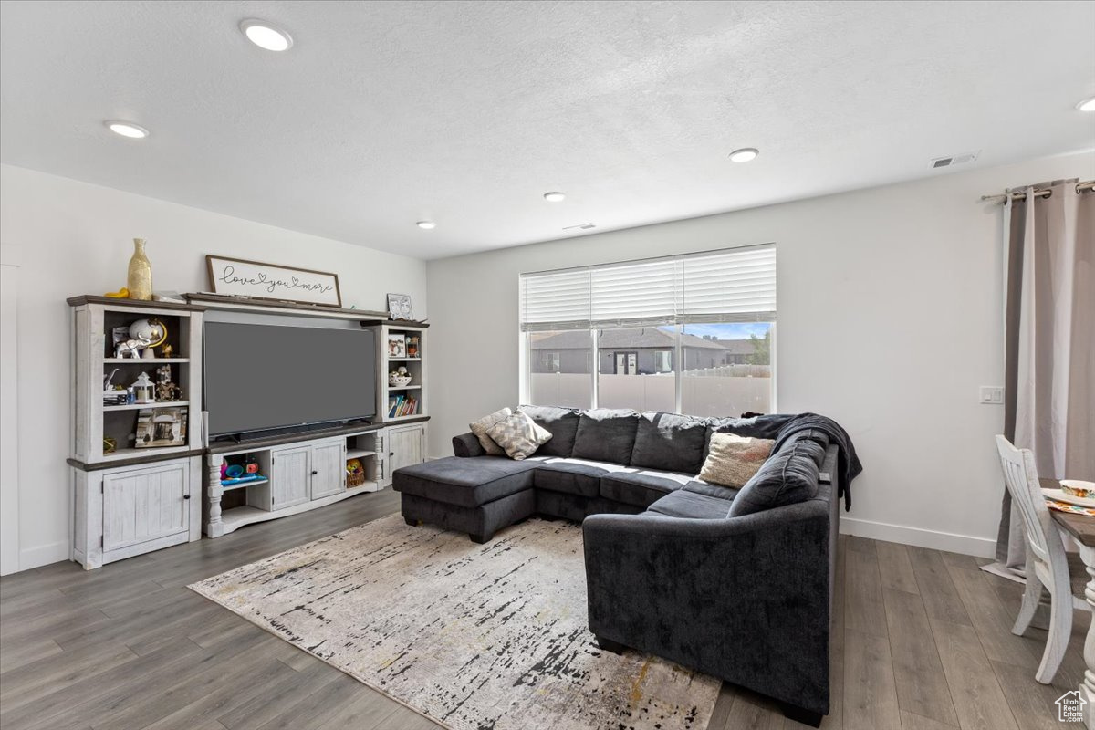 Living room featuring hardwood / wood-style floors and a textured ceiling