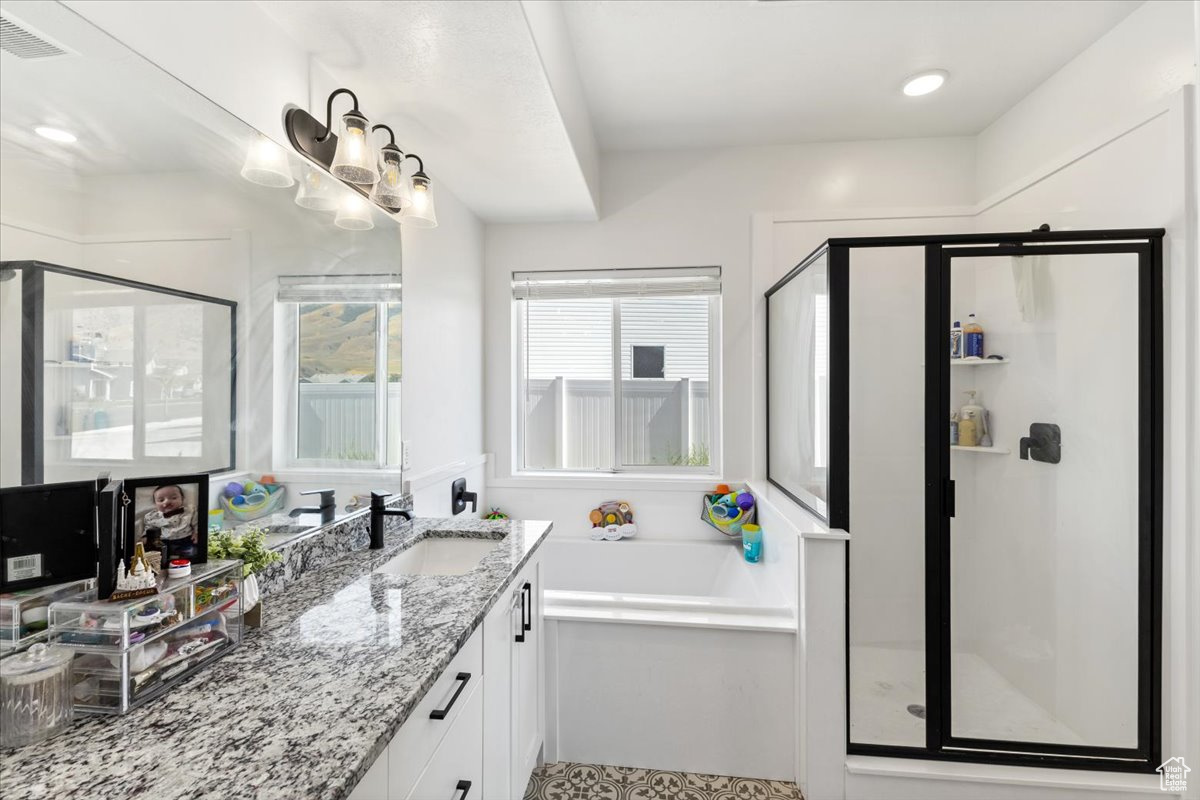 Primary bathroom featuring vanity, plus walk in shower.