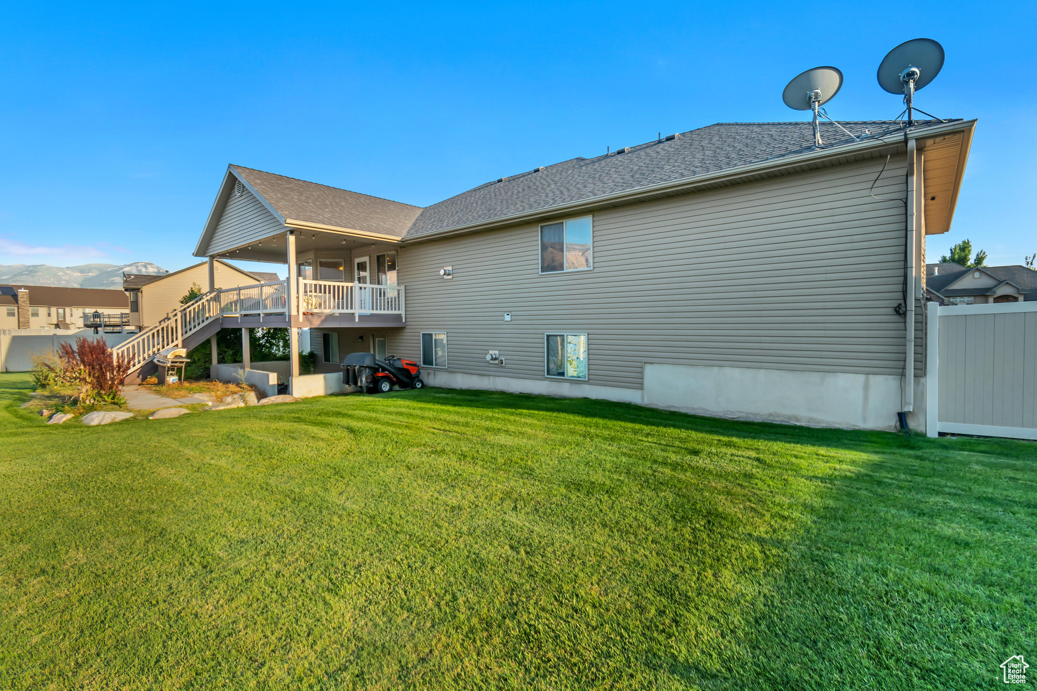 Rear view of property featuring a yard and a wooden deck