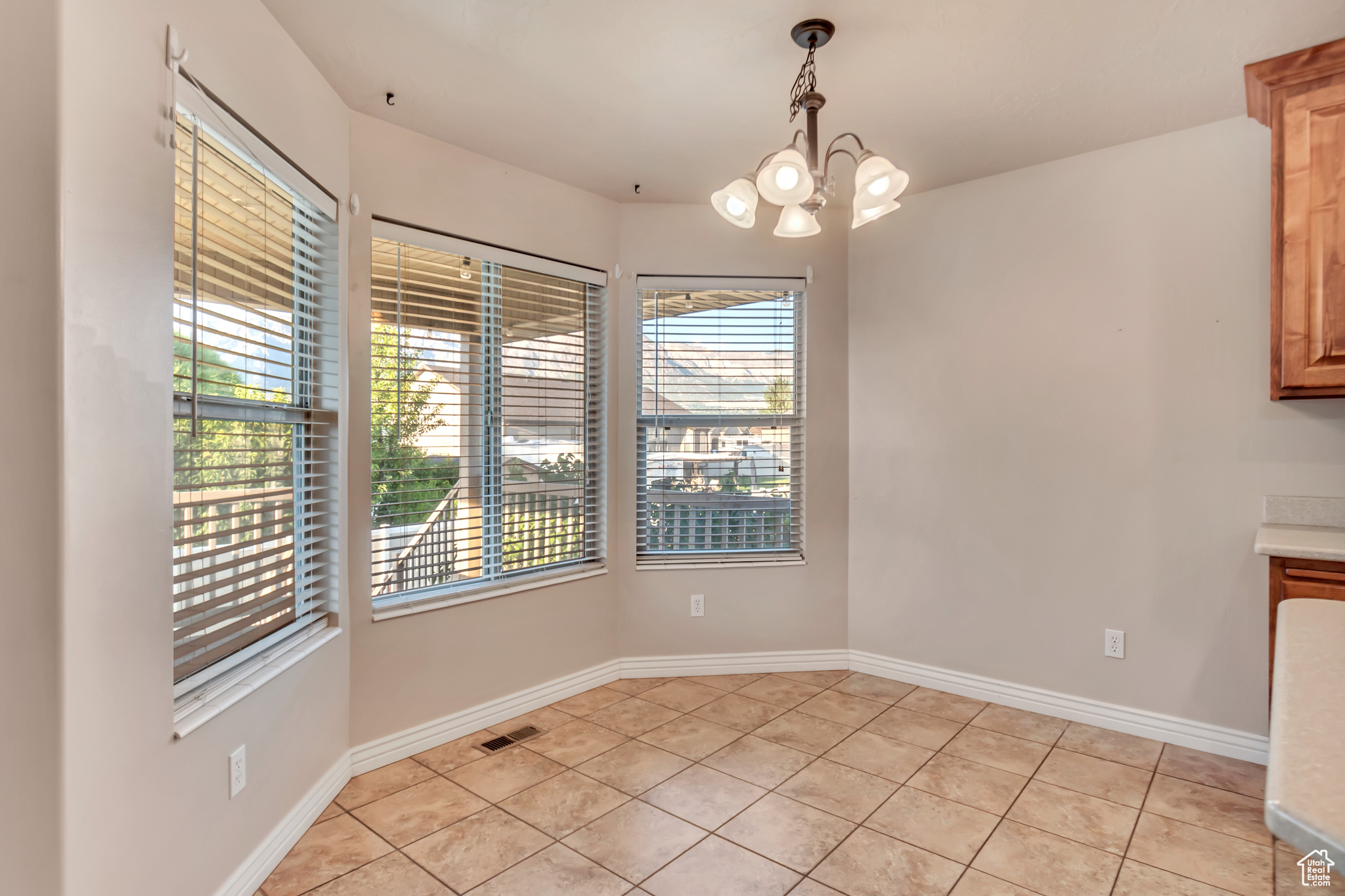 Unfurnished dining area with a notable chandelier and light tile patterned floors