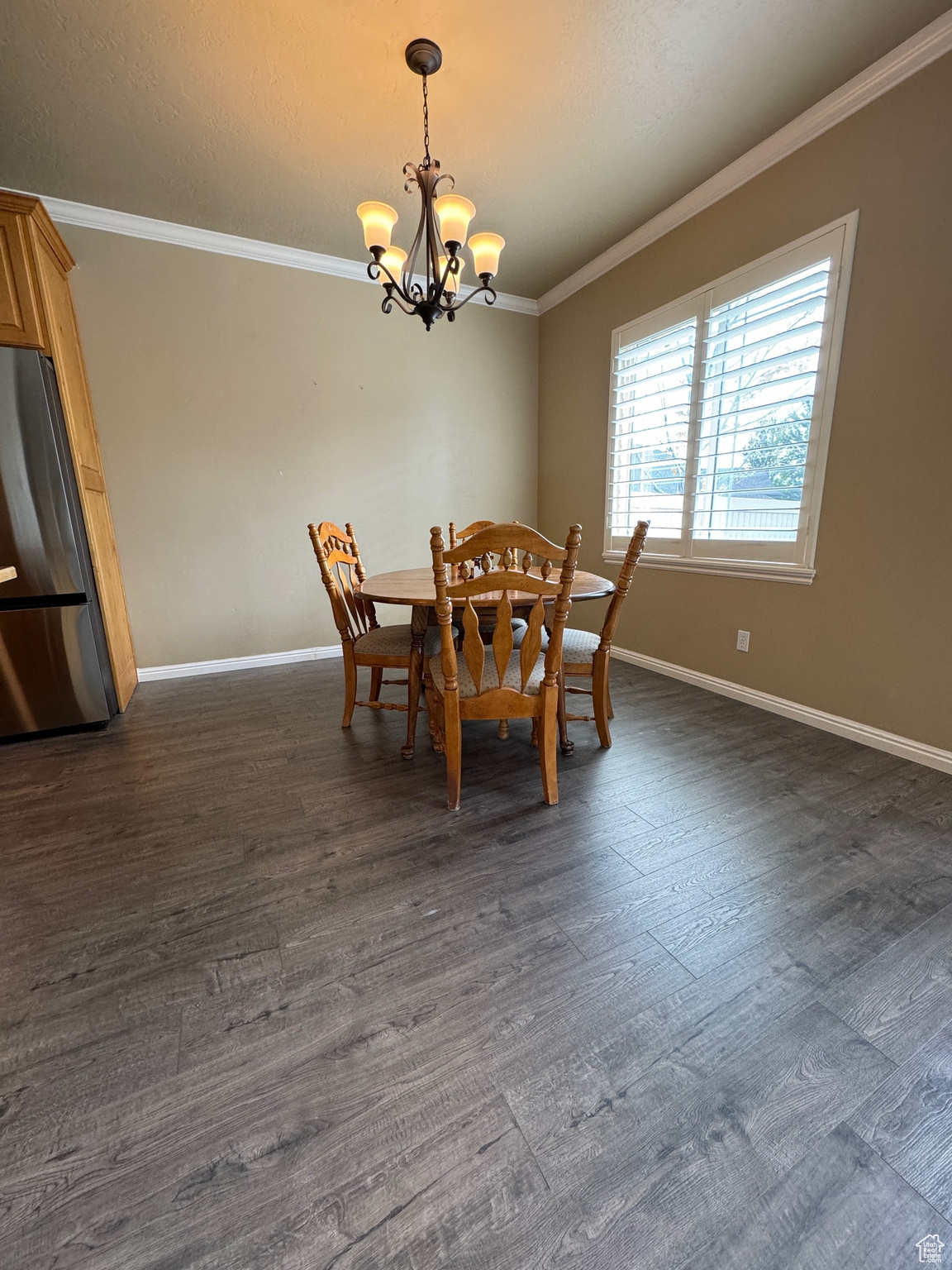 Dining area with crown molding, chandelier, and dark hardwood floors