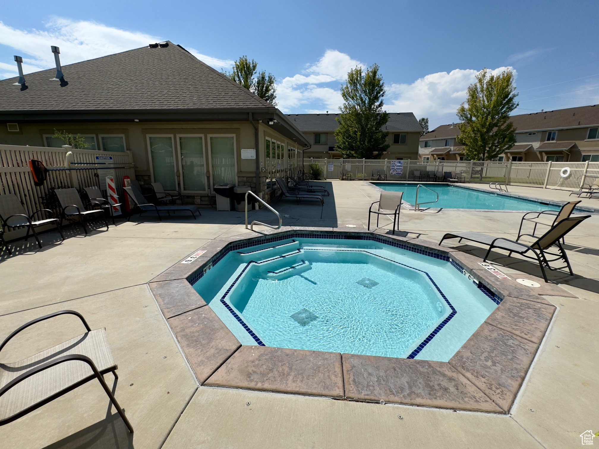 View of swimming pool featuring a community hot tub and a patio